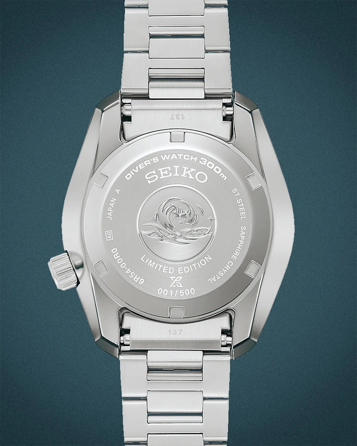 Back of a silver Seiko diver's watch with stainless steel bracelet, engraved wave design, and "Limited Edition 001/500" text.