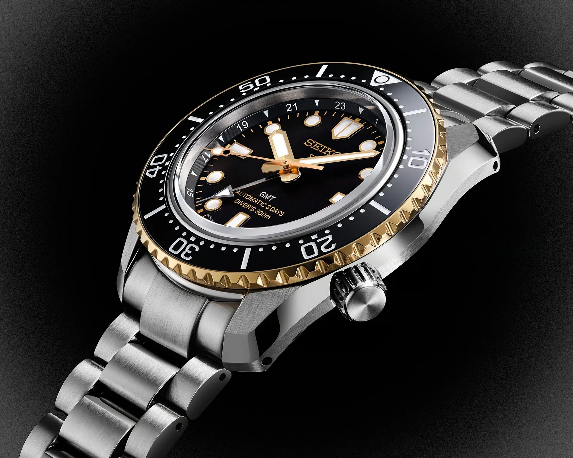 Stainless steel Seiko diver's watch with black and gold bezel and black dial on a metal bracelet.