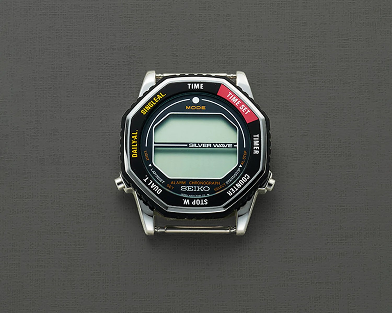 Seiko Silver Wave digital watch face with black octagonal bezel and multiple function labels on a gray textured background.