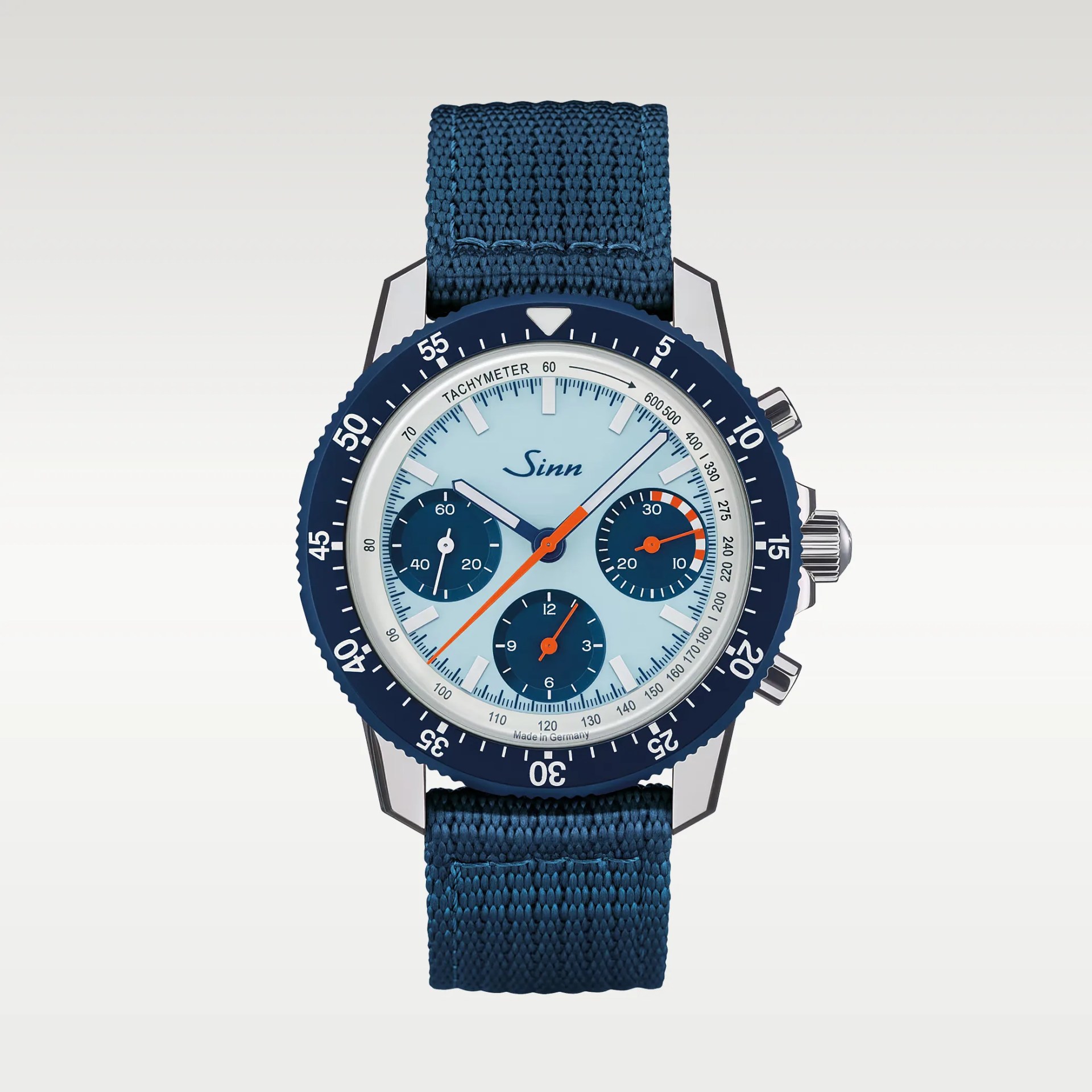 Blue Sinn chronograph watch with light blue dial, three subdials, orange hands, and blue fabric strap.