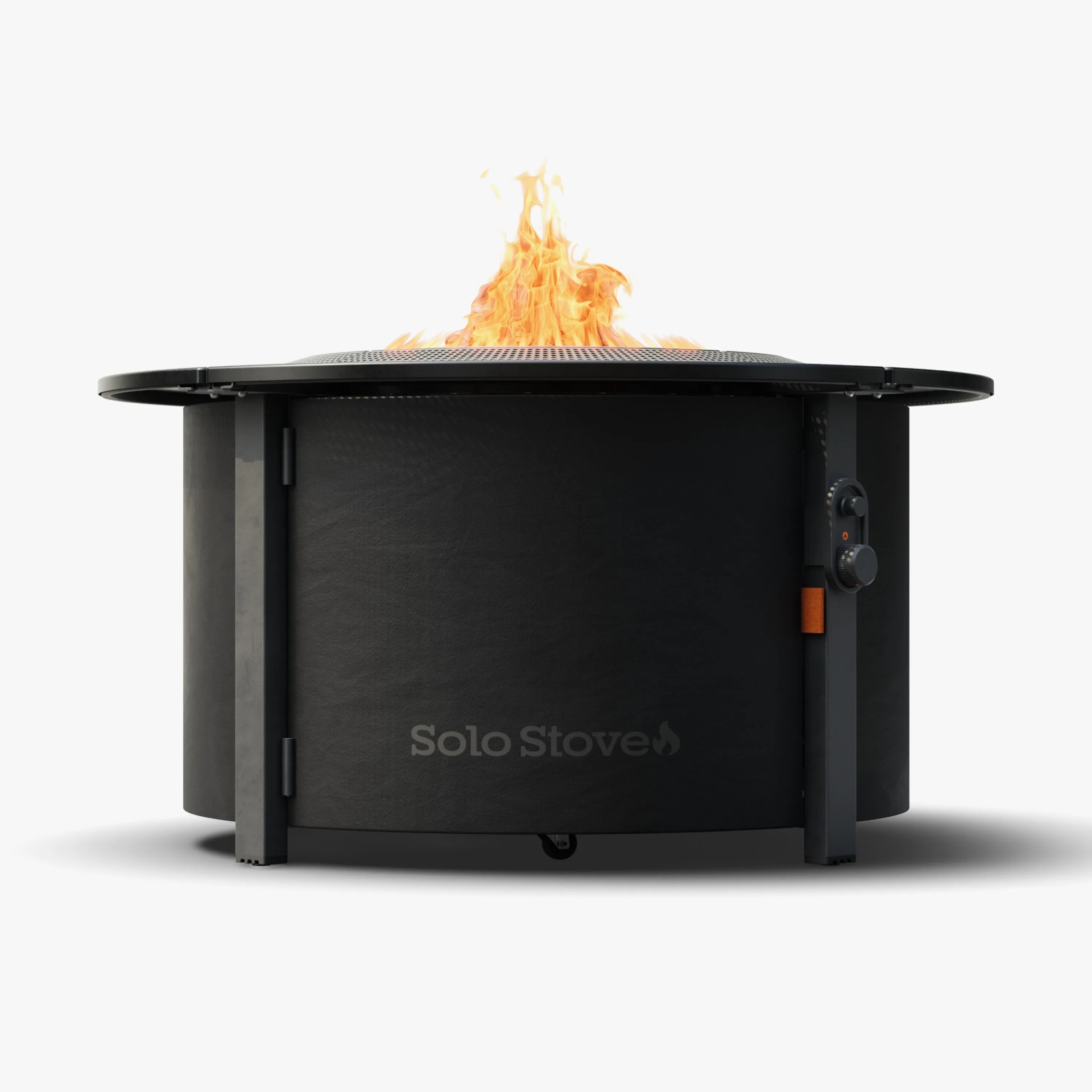Black round metal fire pit with a mesh cover and visible orange flames on top.