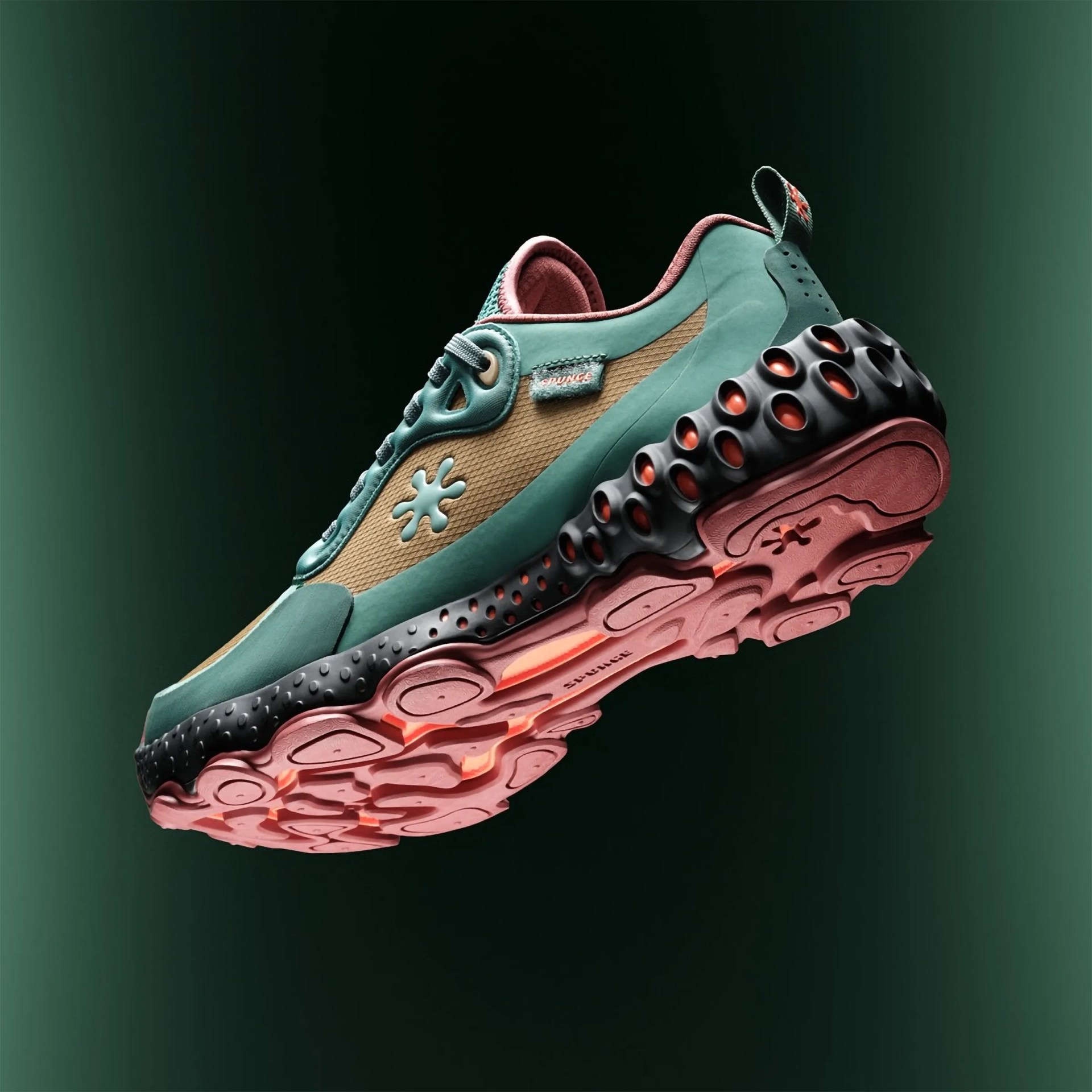 Green and tan sneaker with black and pink textured sole floating against dark green background.