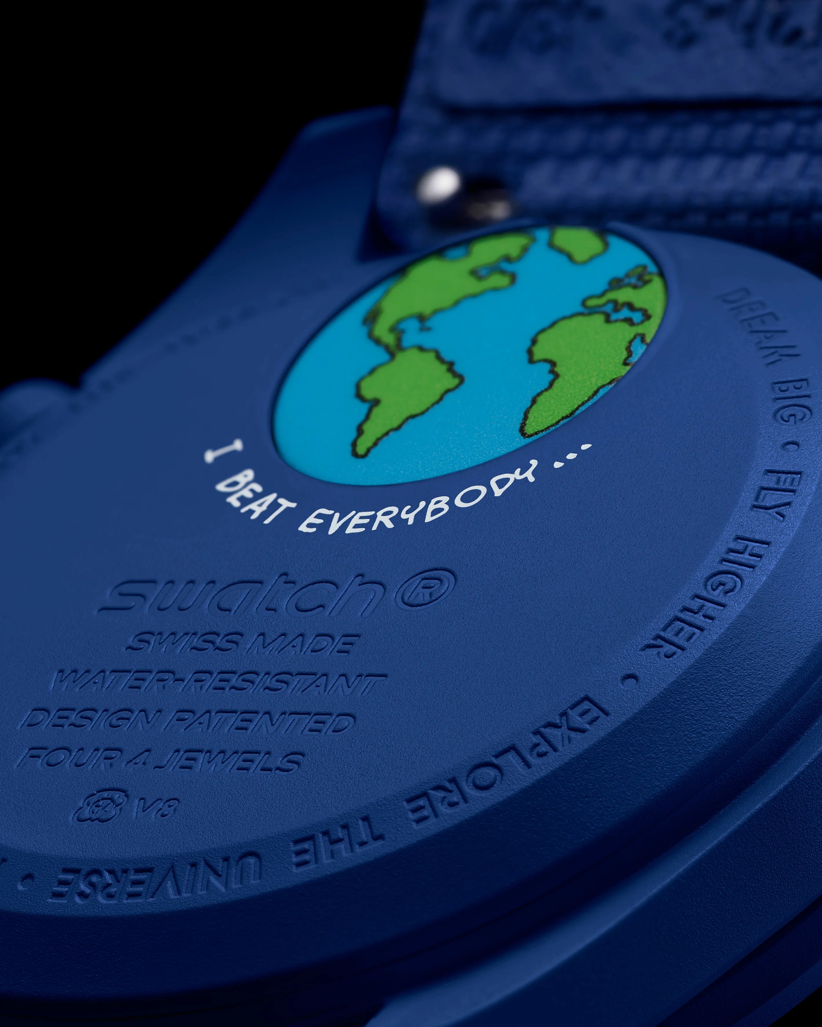 Close-up of a blue Swatch watch back with a green and blue Earth graphic and white text "I BEAT EVERYBODY...