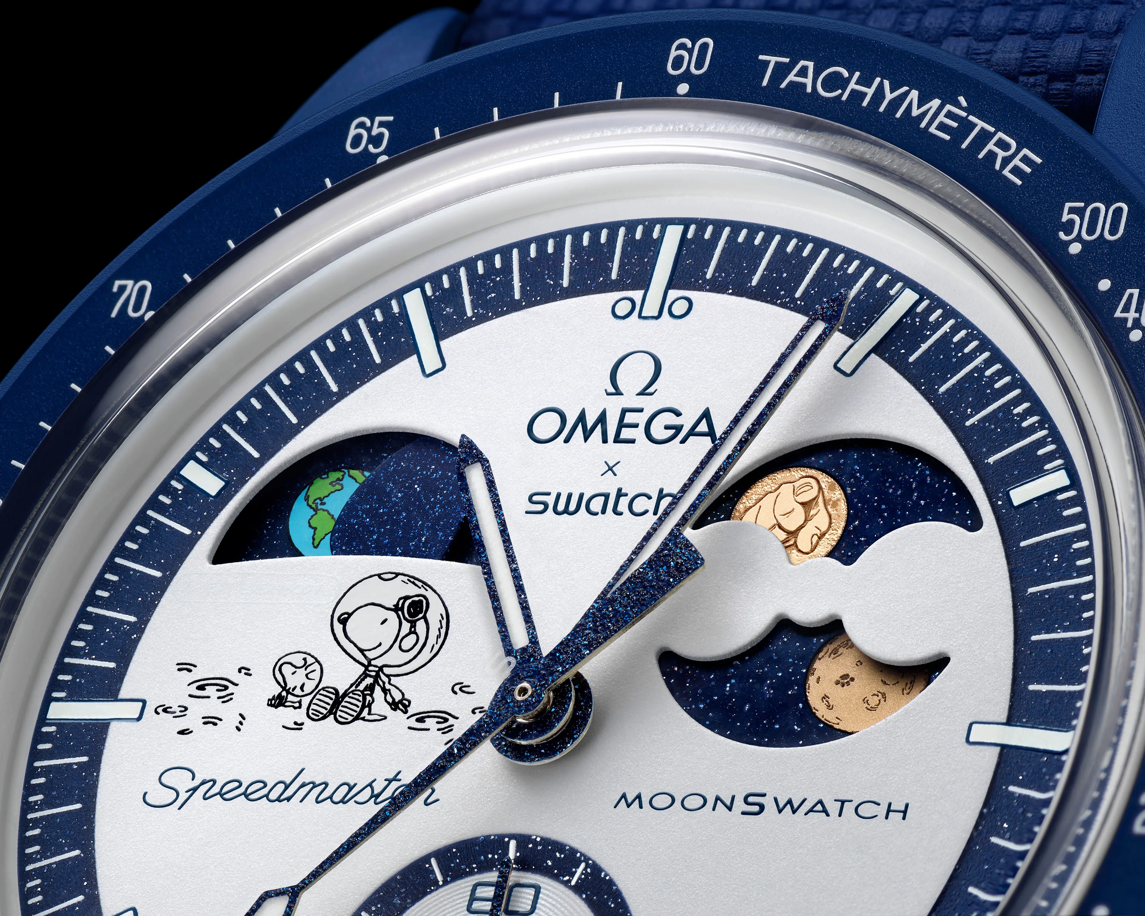 Close-up of a blue and white Omega x Swatch Speedmaster MoonSwatch watch face featuring Snoopy in a spacesuit and celestial designs.