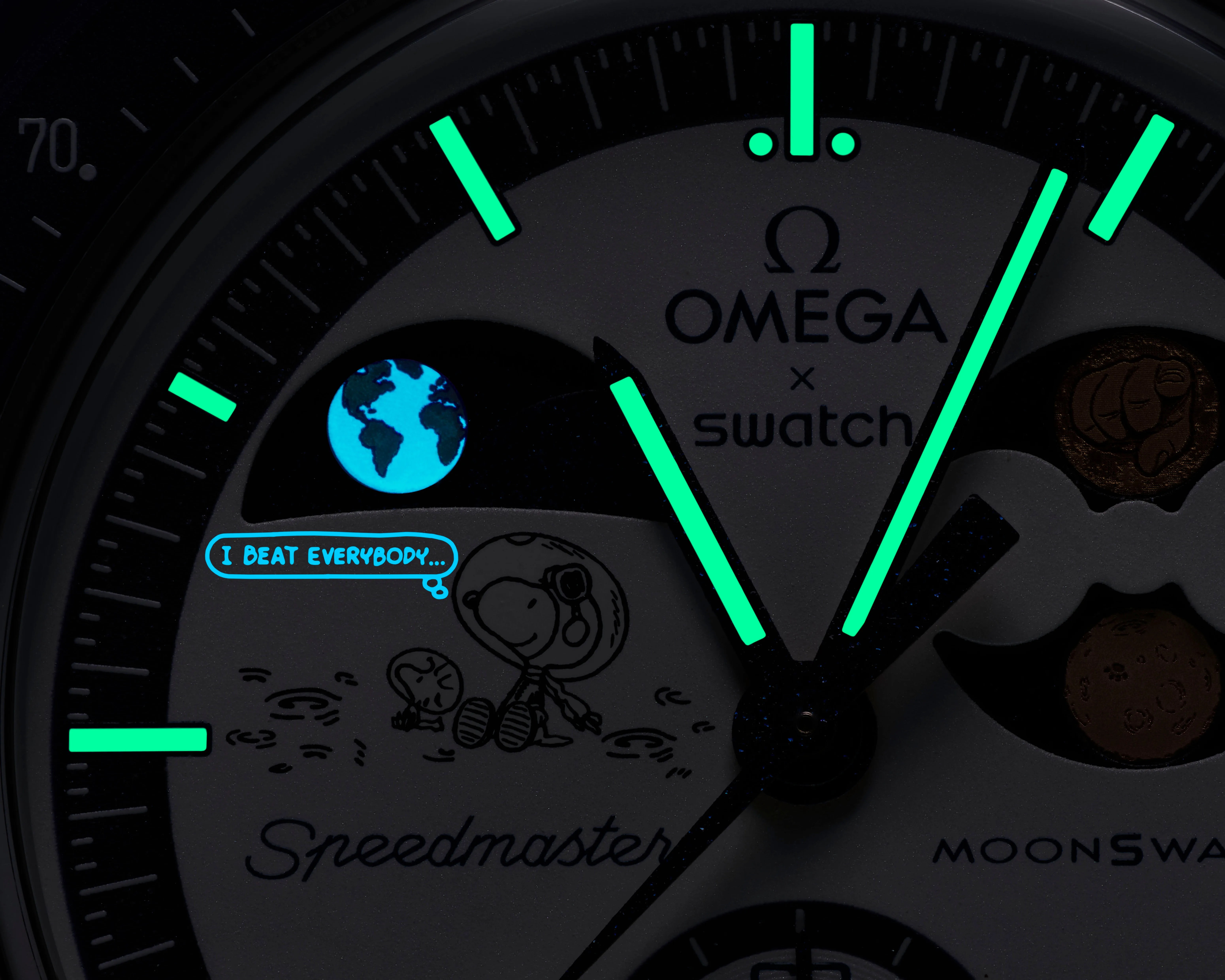 Close-up of an Omega x Swatch Speedmaster watch face with glowing green hands and markers, featuring Snoopy in a spacesuit and a glowing Earth.