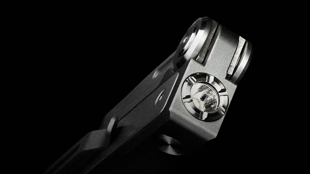 Close-up of a metallic hinge or joint with a large screw and textured surface against a black background.