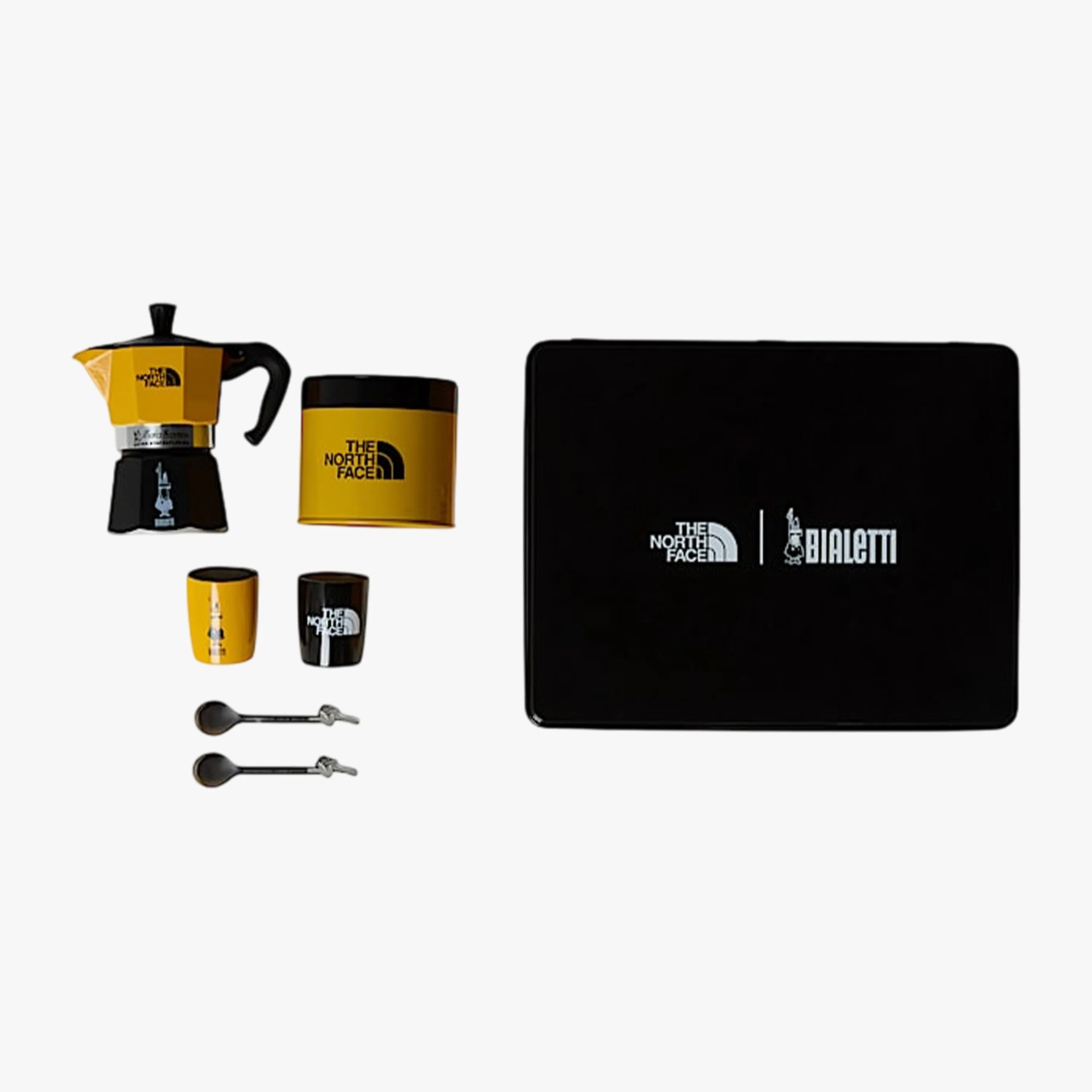 Yellow and black moka pot coffee set with two cups, two spoons, and a black box featuring The North Face and Bialetti logos.