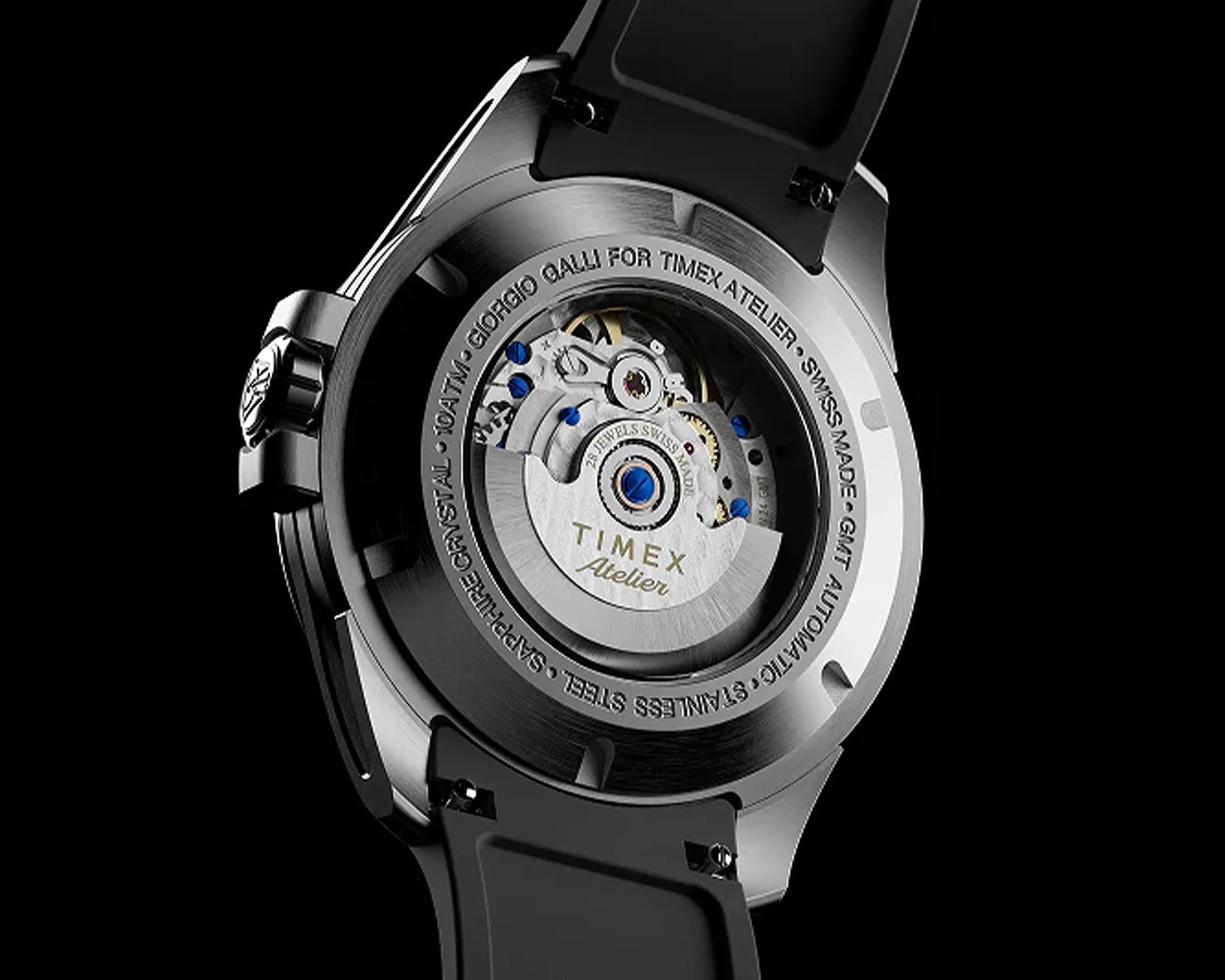 Back of a Timex Atelier watch showing its automatic movement with visible gears and blue screws, black strap.