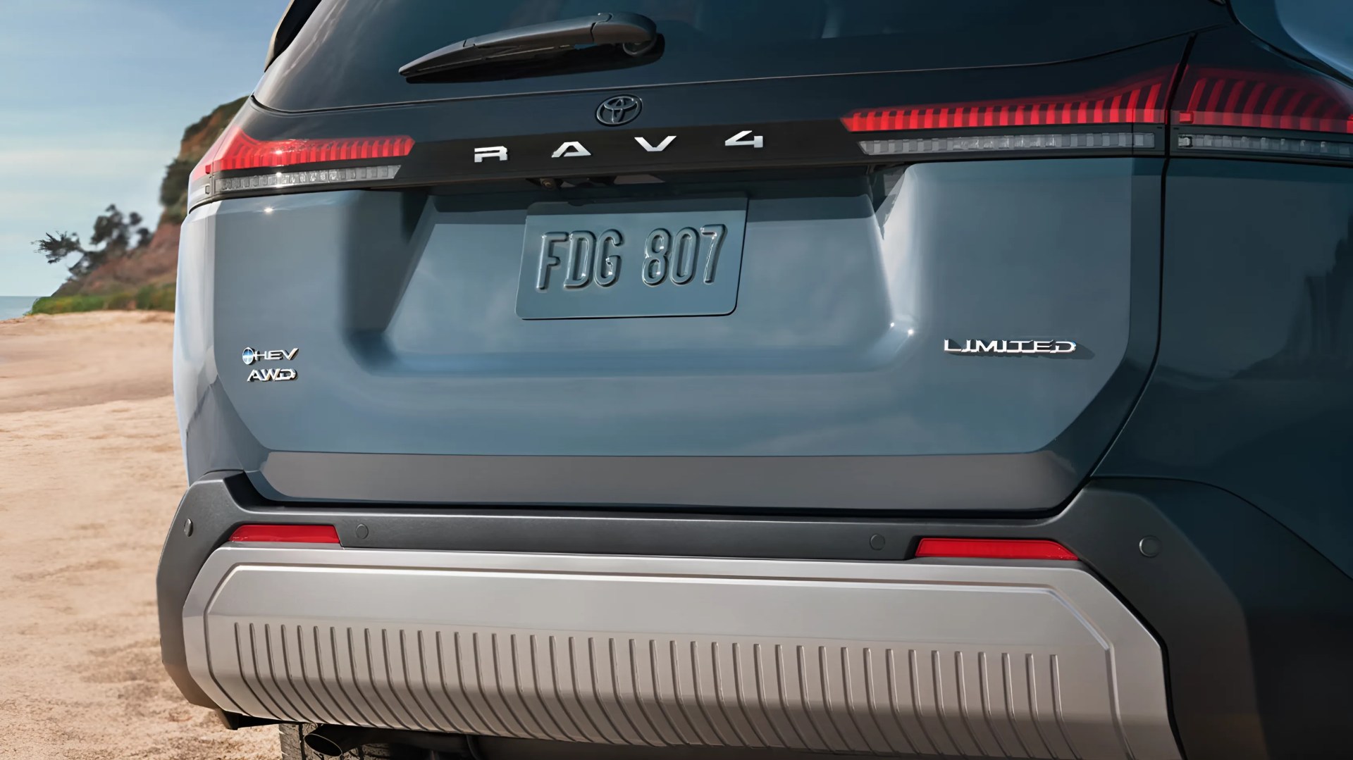 Rear view of a blue Toyota RAV4 Limited AWD hybrid SUV with visible taillights and license plate FDG 807.