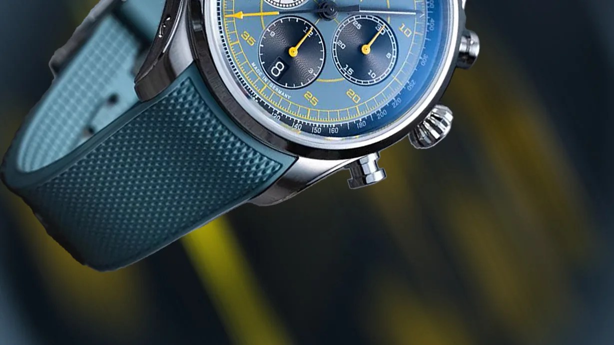 Blue chronograph wristwatch with yellow accents and textured blue rubber strap.