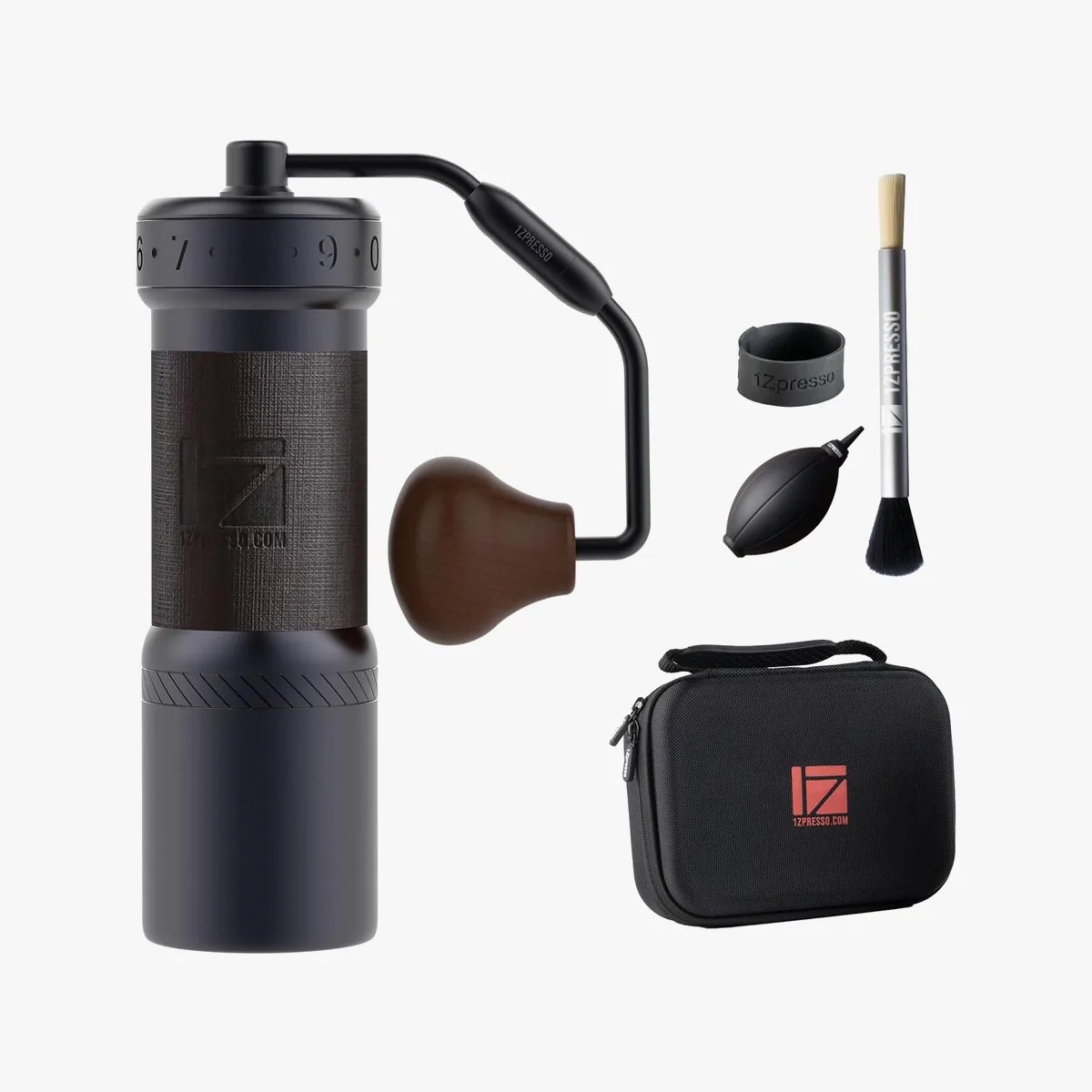 Black and brown manual coffee grinder with wooden handle, cleaning brush, air blower, silicone ring, and black carrying case.