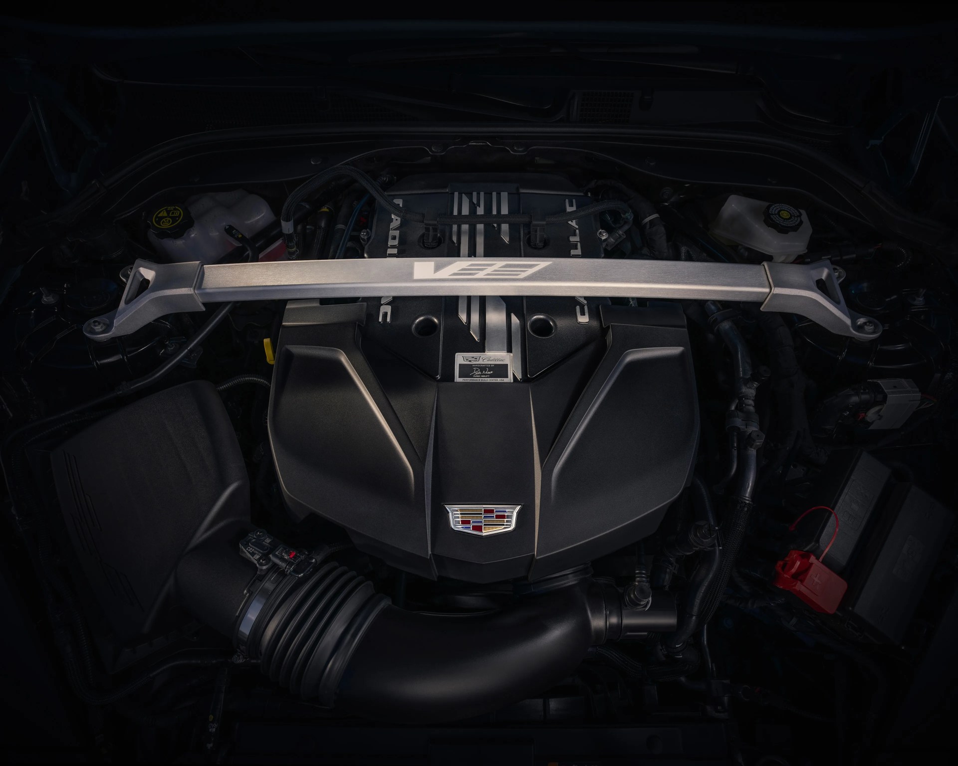 Cadillac V-Series engine with black cover and silver strut bar across the top.