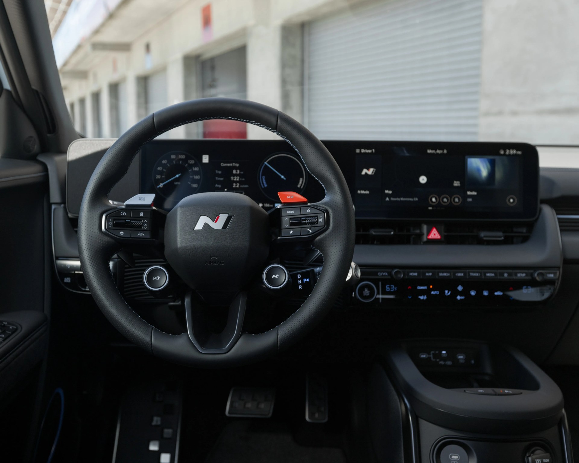 Black leather-wrapped steering wheel with N logo and digital dashboard in a modern car interior.