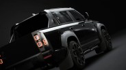 Black electric pickup truck with illuminated square taillights on a dark background.