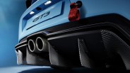 Rear close-up of a light blue GT3 sports car showing dual exhaust pipes, carbon fiber diffuser, and red tow strap.