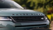 Front grille and hood of a green Range Rover with black lettering and Land Rover badge.