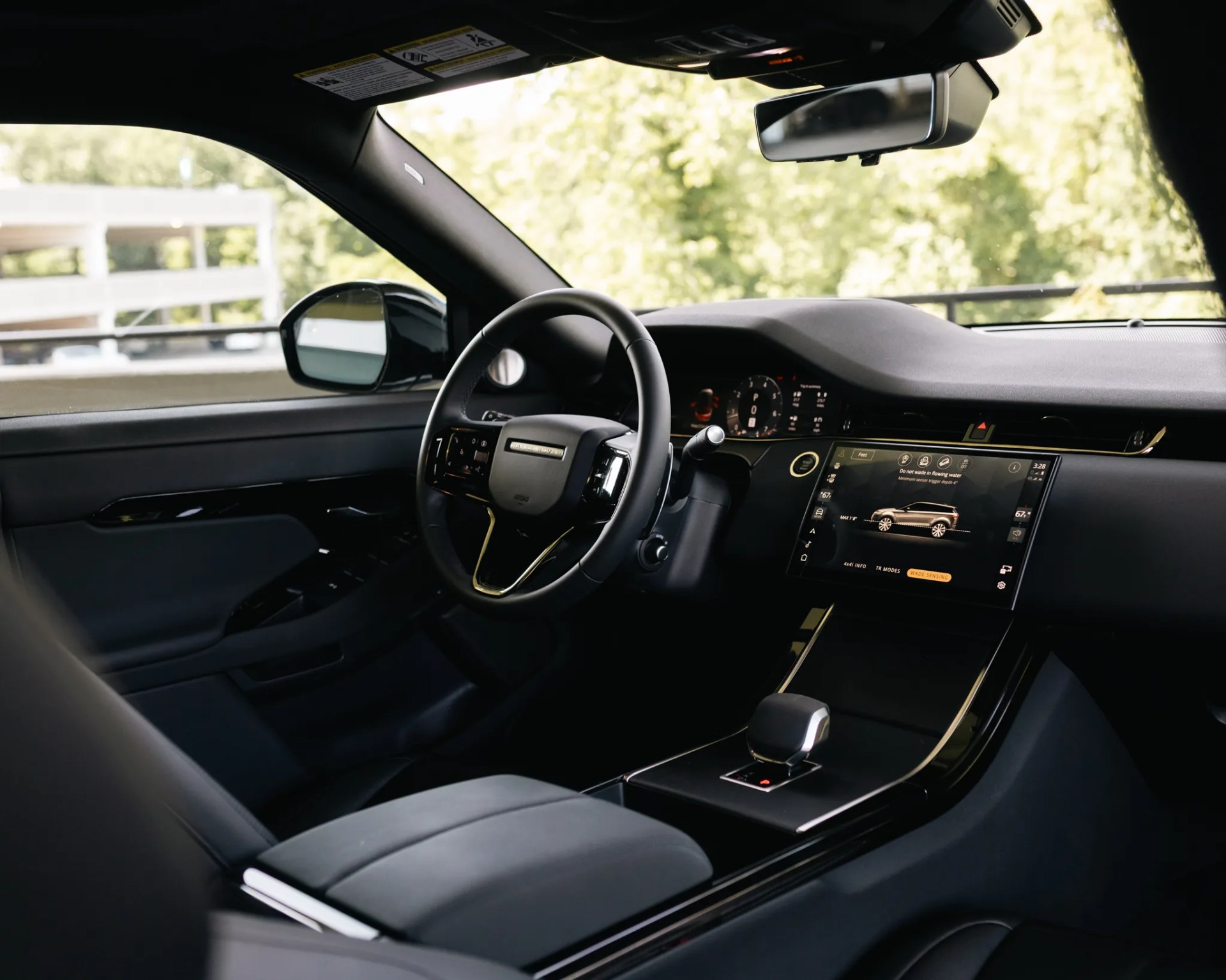 Interior of a modern black car featuring a digital dashboard, touchscreen display, and leather seats.