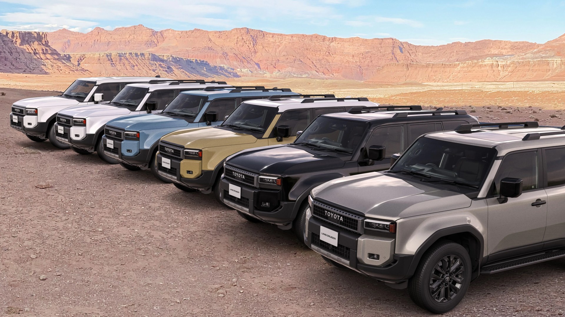 Seven Toyota Land Cruiser SUVs in various colors lined up on a dirt surface with rocky hills in the background.