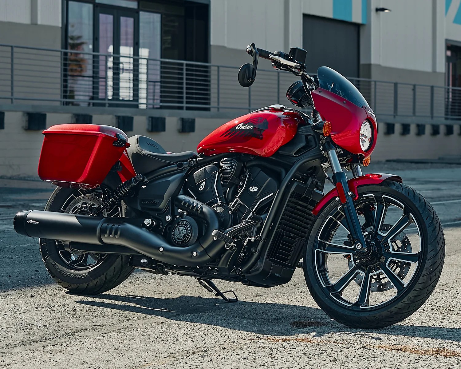Red and black Indian motorcycle with a front fairing and rear storage box parked on pavement.