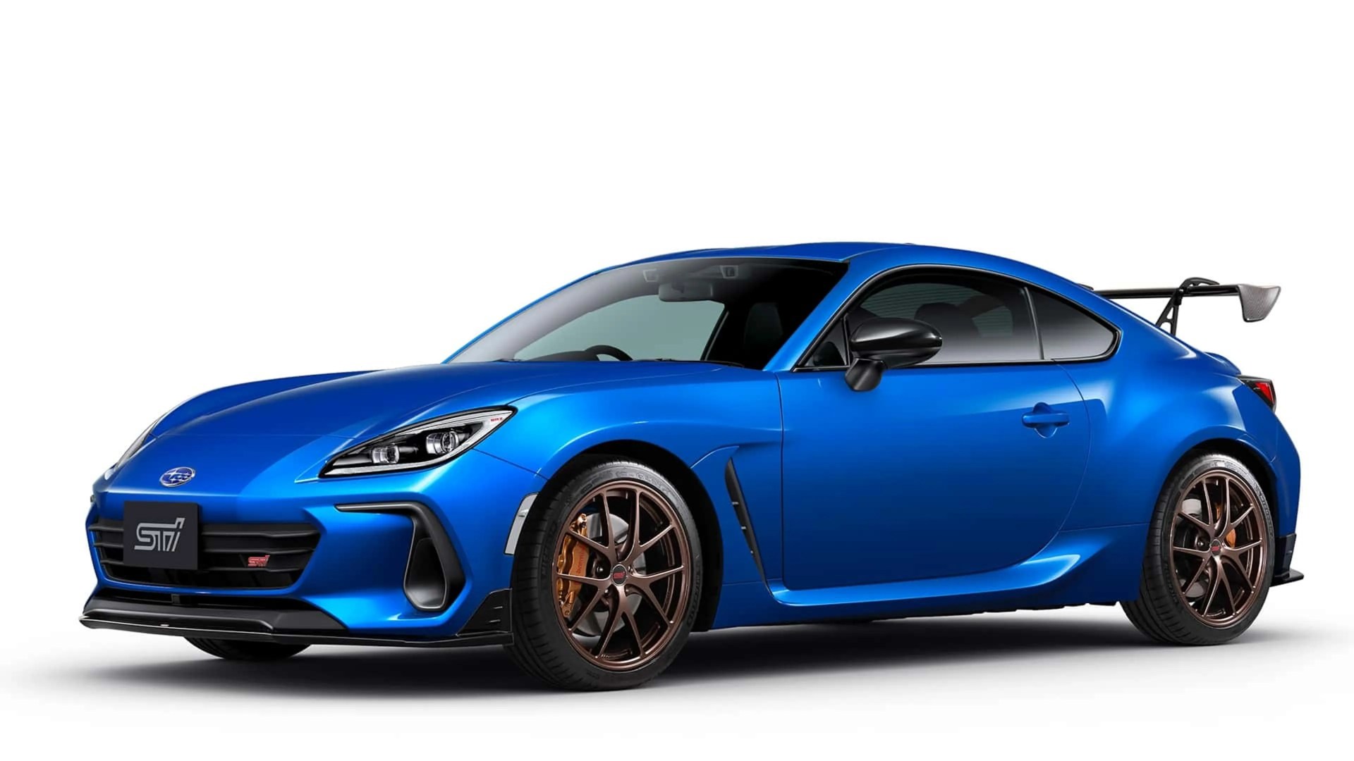 Blue Subaru sports coupe with bronze alloy wheels and large rear spoiler on a white background.