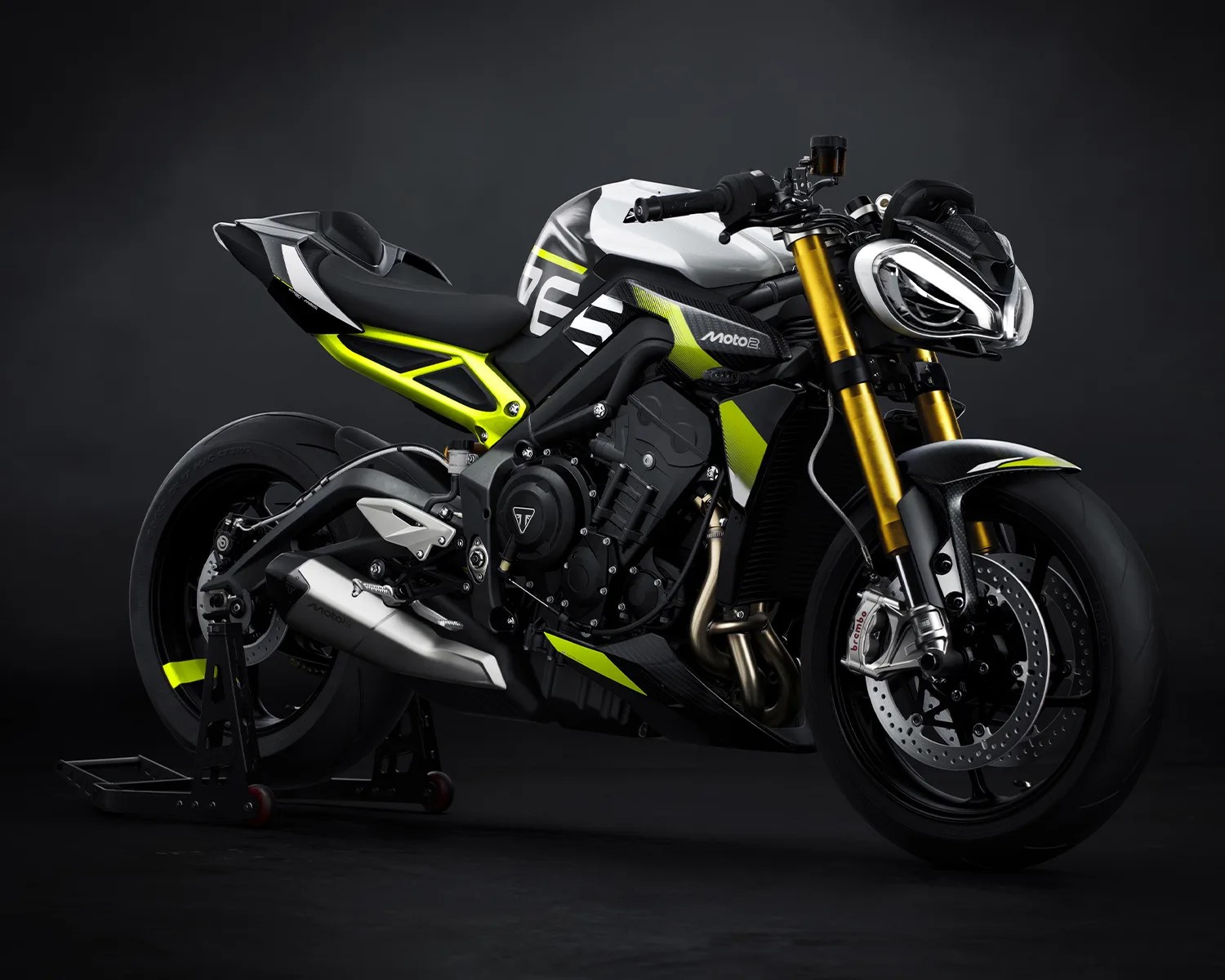 Black and white sport motorcycle with neon yellow accents and gold front forks on a black stand.