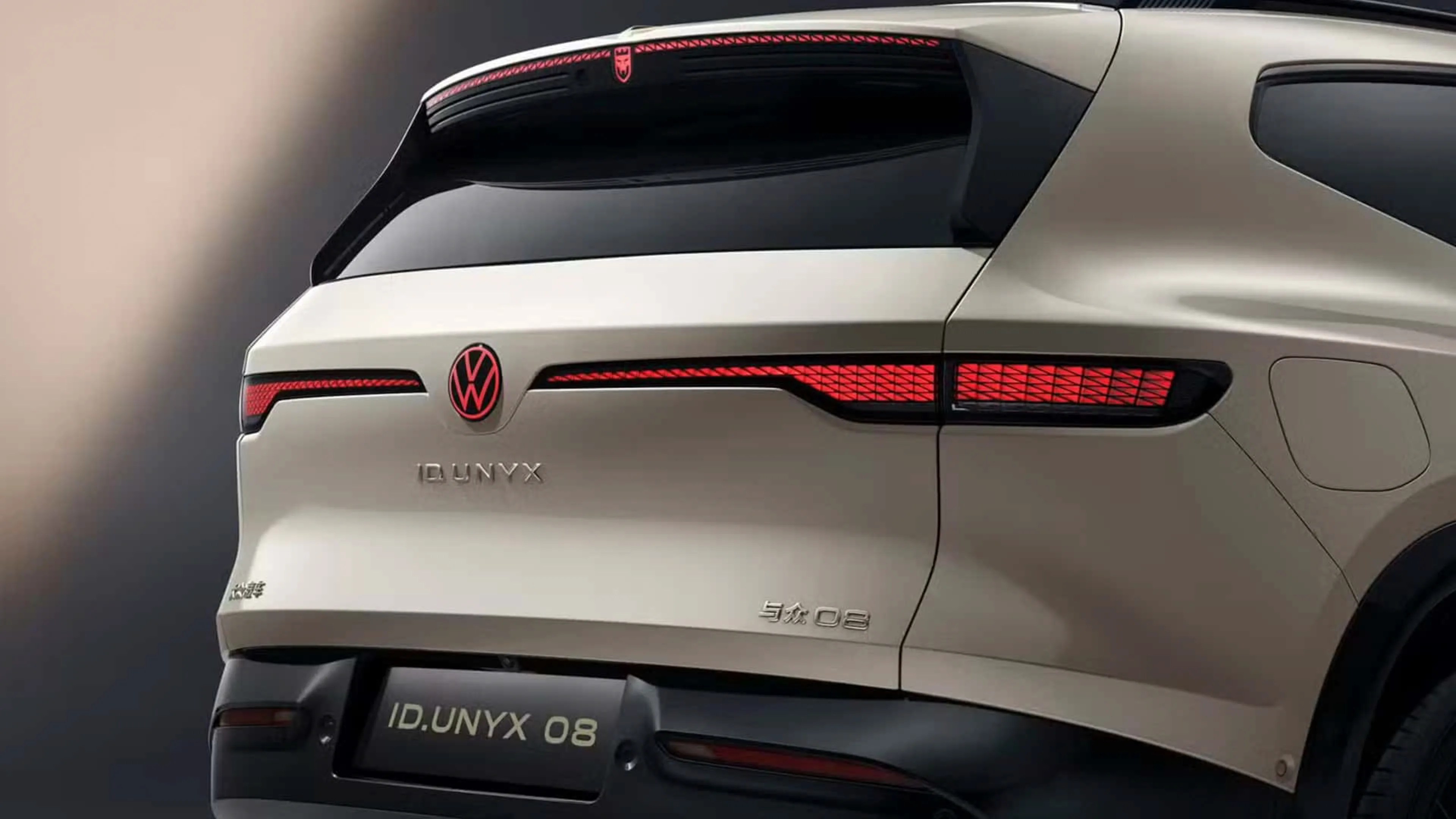 Rear view of a beige Volkswagen ID. UNYX 08 electric SUV with illuminated red taillights and black rear bumper.