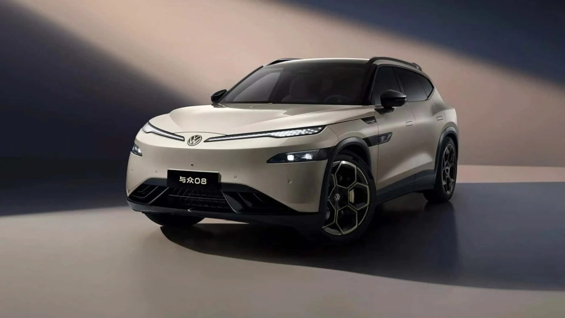 Beige Volkswagen electric SUV with black roof and geometric alloy wheels in a studio setting.