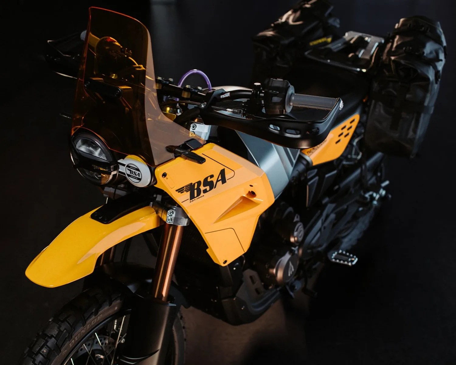 Yellow BSA motorcycle with black and silver details, featuring a tinted windshield and saddlebags.
