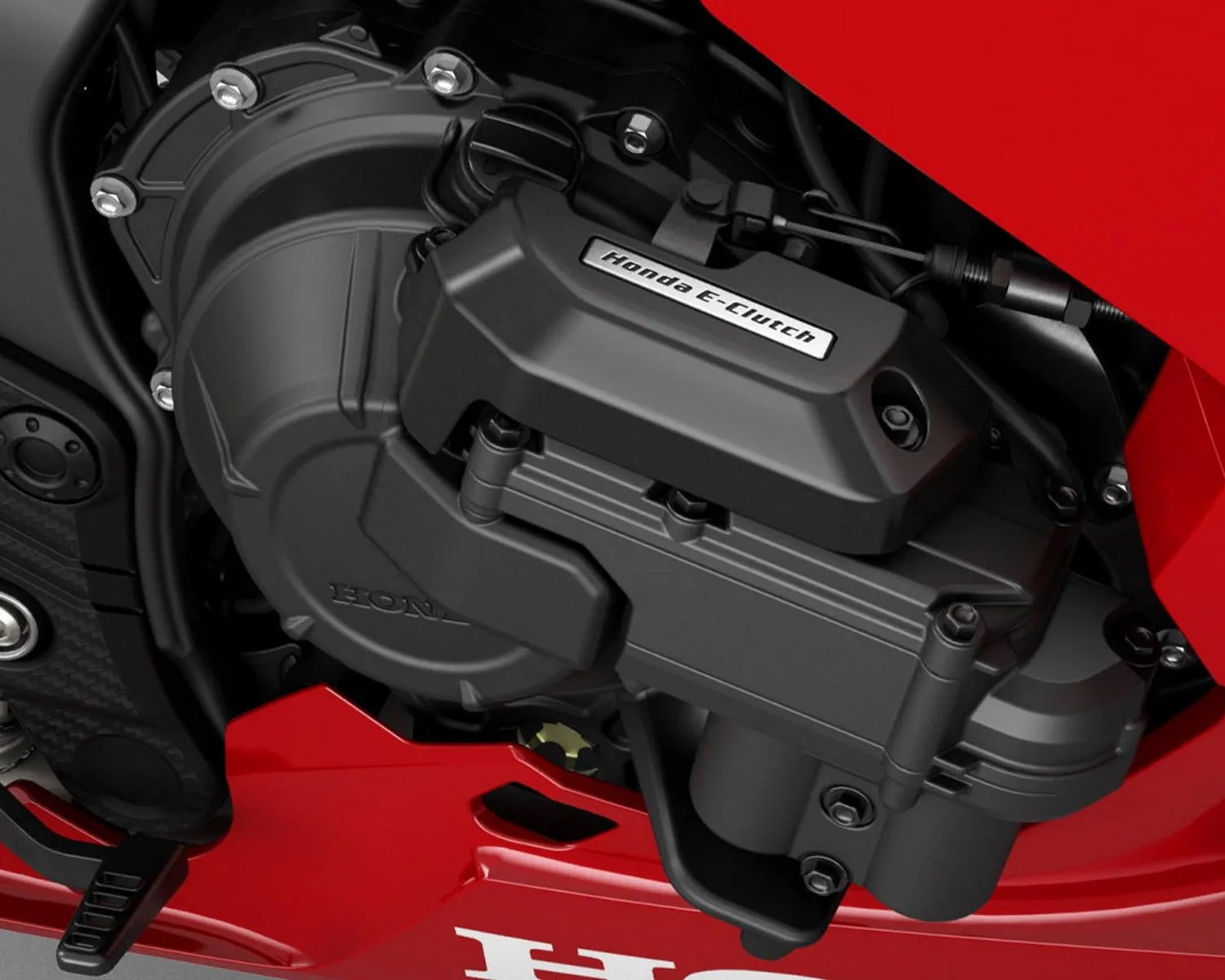 Close-up of a black Honda E-Clutch engine component on a red motorcycle.