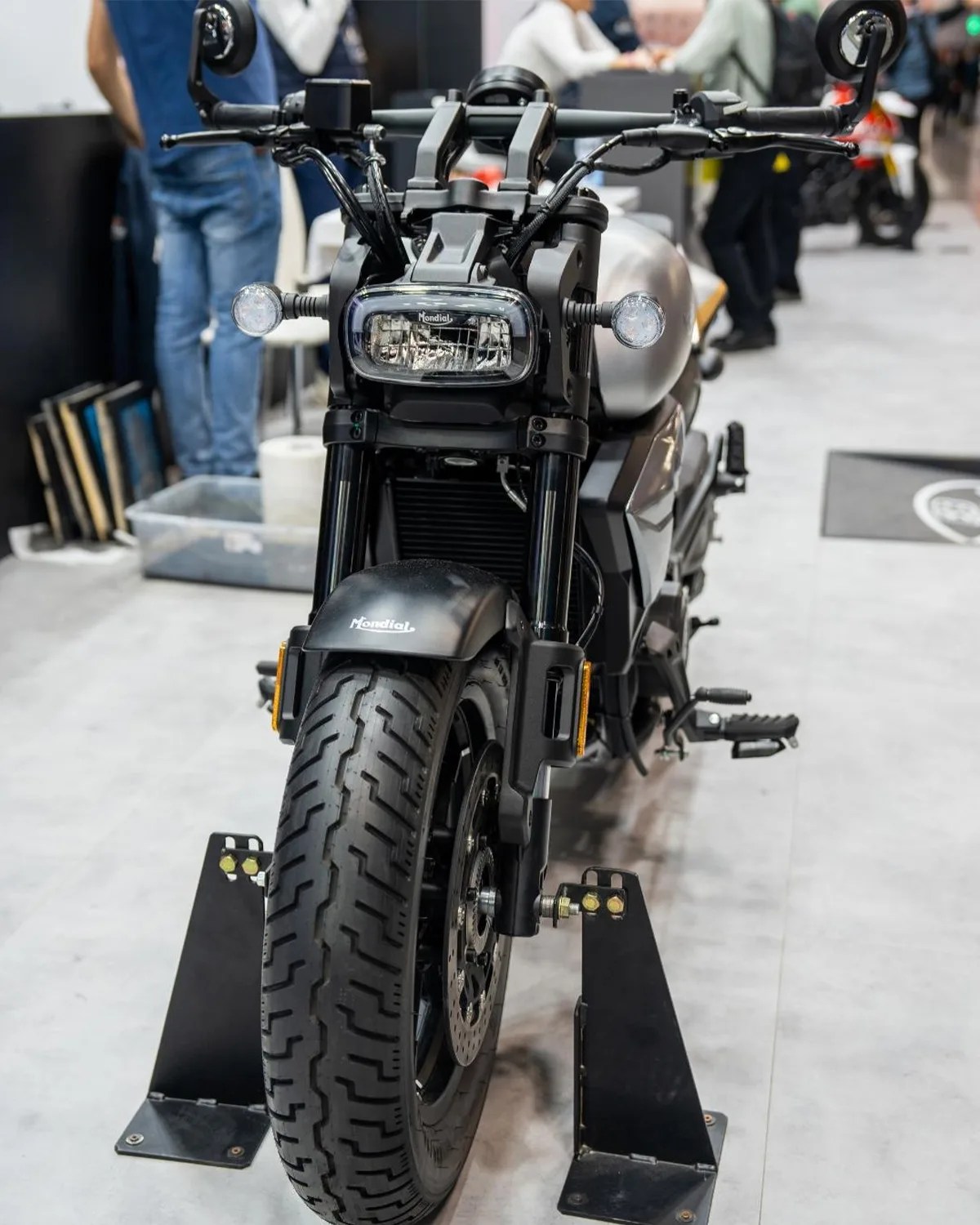 Front view of a black and silver Mondial motorcycle on a display stand indoors.