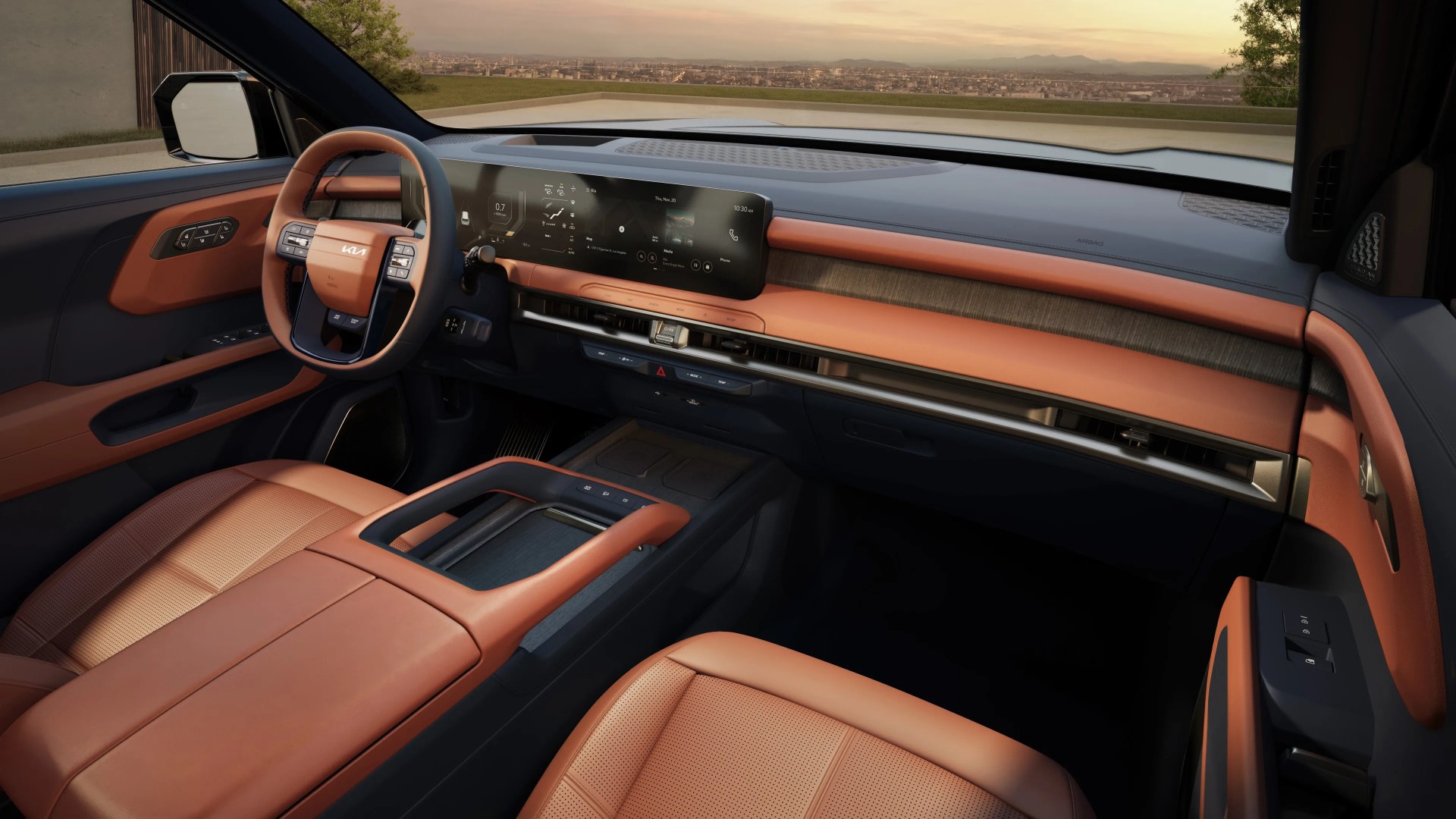 Car interior with tan leather seats, matching steering wheel, wood trim, and a wide digital dashboard display.