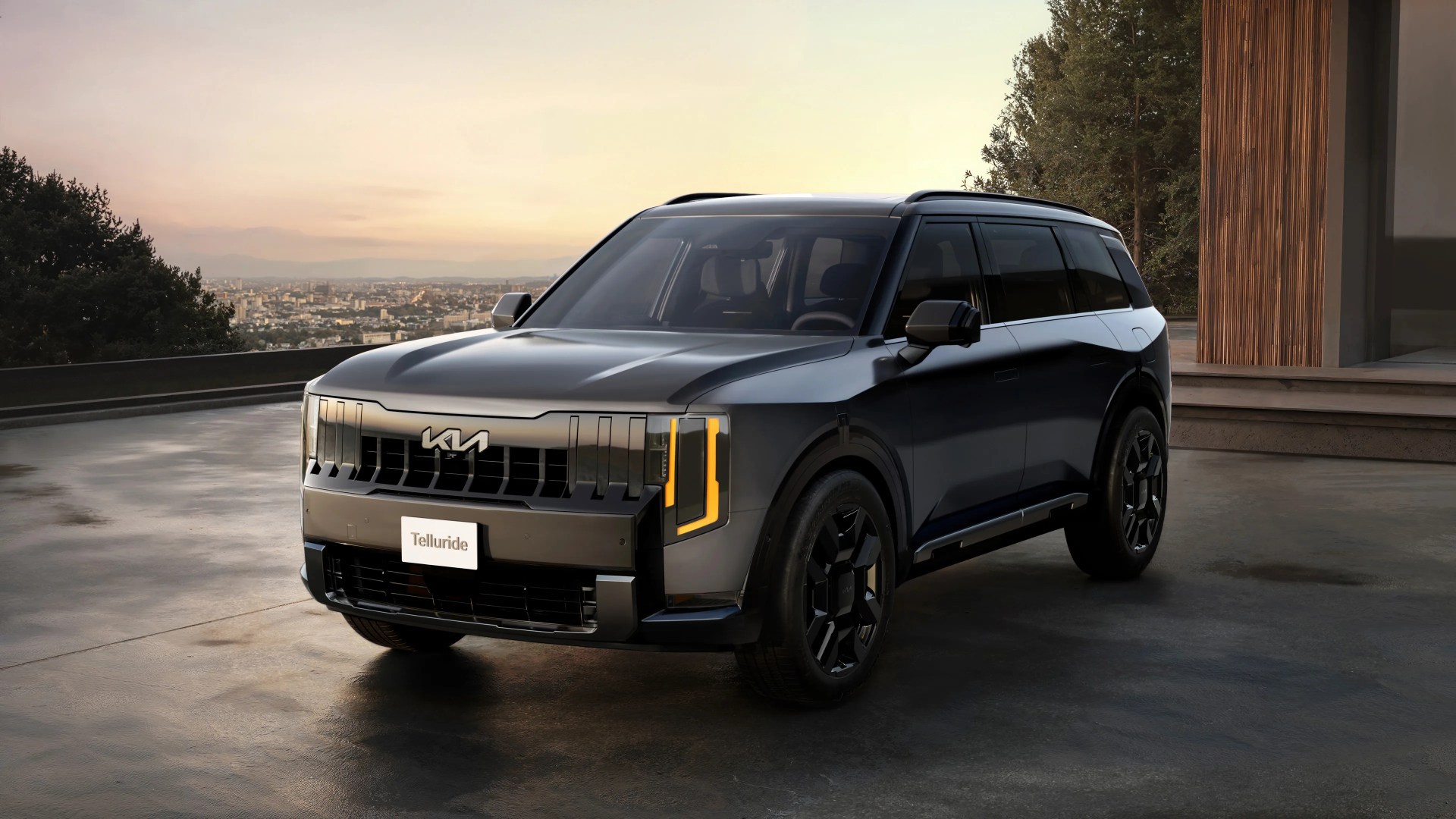 Black Kia Telluride SUV parked on a concrete driveway near a modern building at sunset.