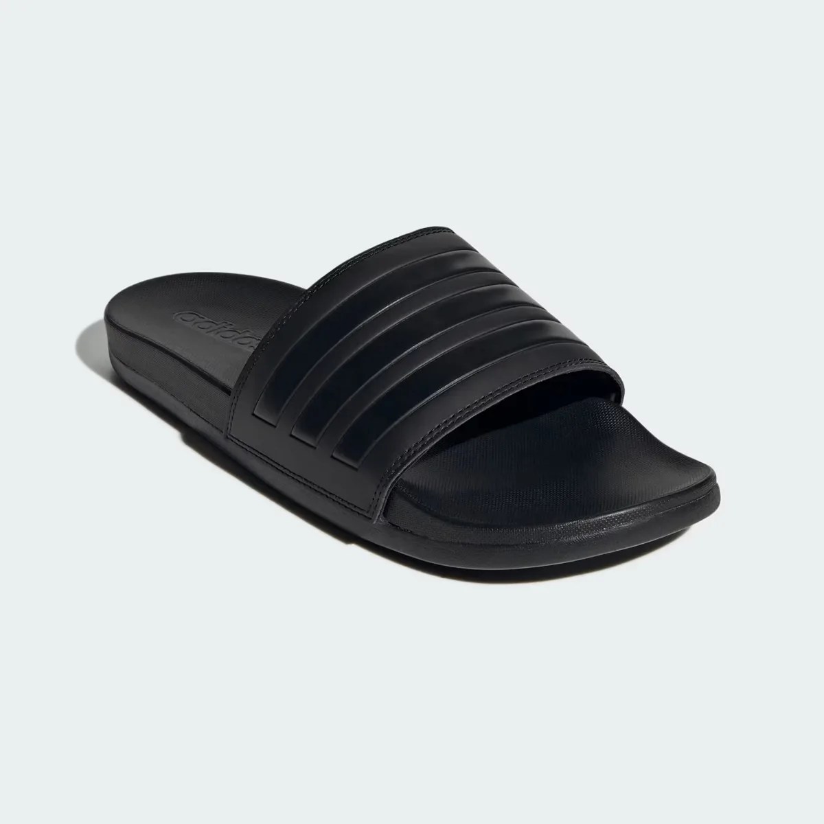 Black Adidas slide sandal with textured footbed and three raised stripes on the strap.
