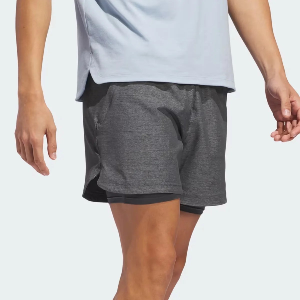 Dark gray athletic shorts with built-in black compression liner worn by a person.