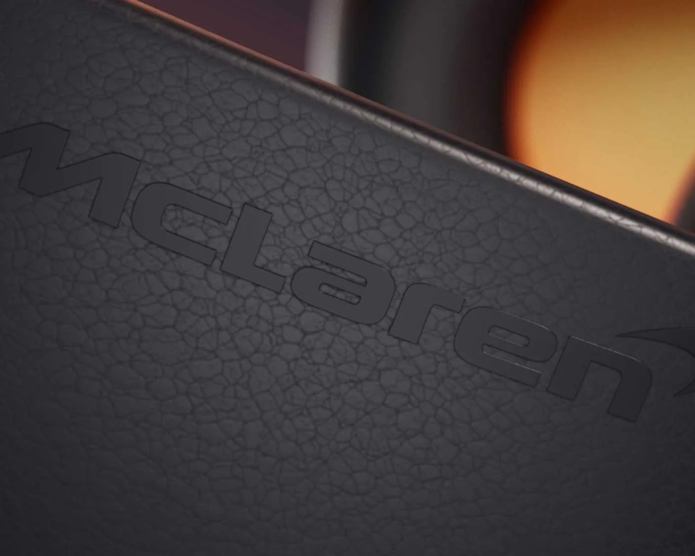 Close-up of a black textured surface with the word "McLaren" embossed on it.