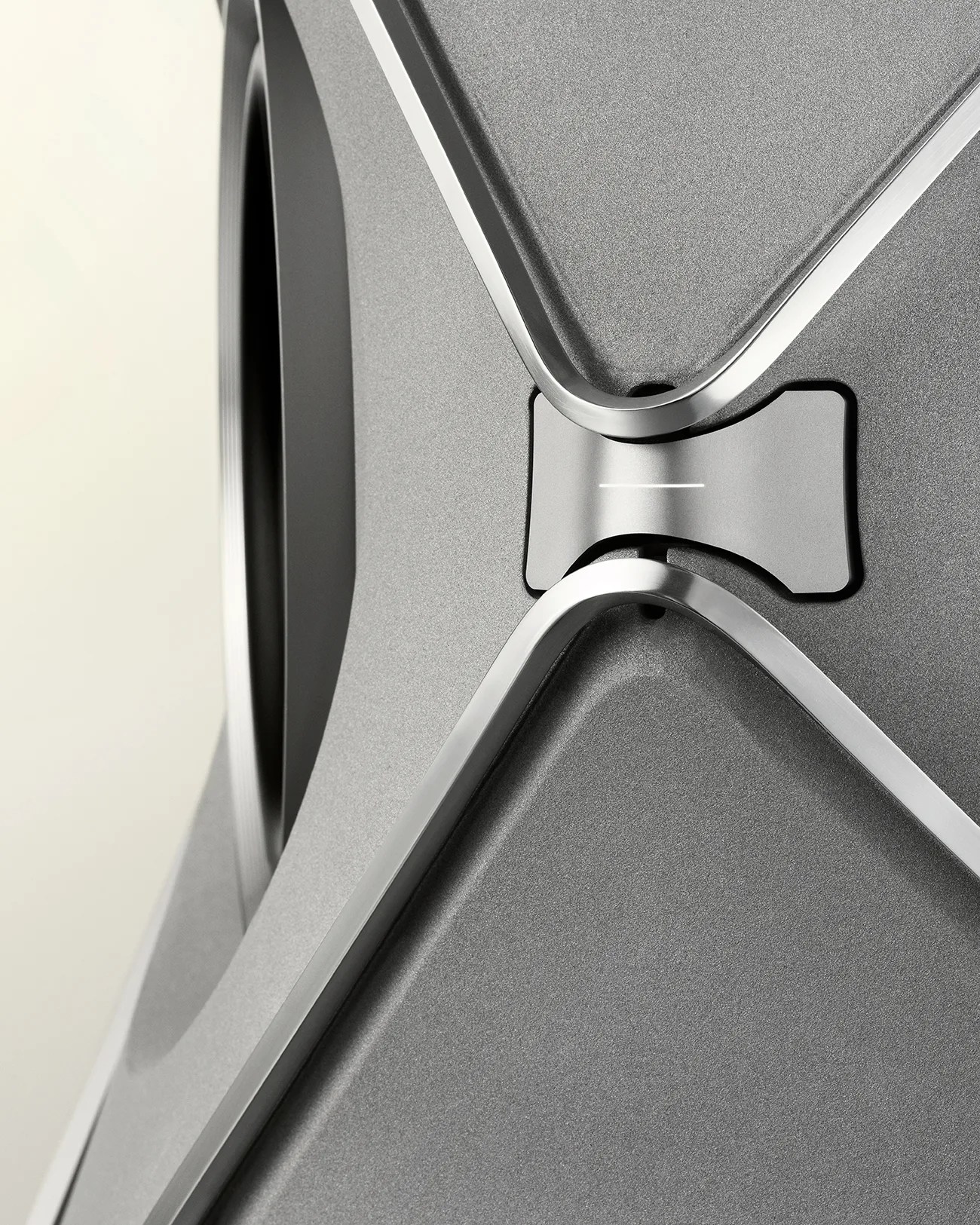 Close-up of a gray metallic speaker with a textured surface and silver trim accents.