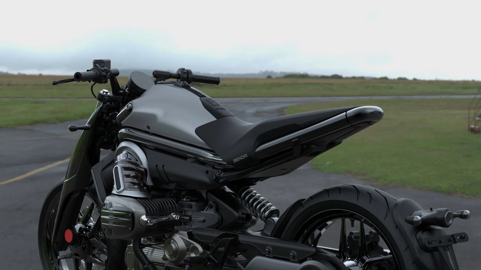 Black and silver Benda motorcycle parked on a paved area with grassy fields in the background.