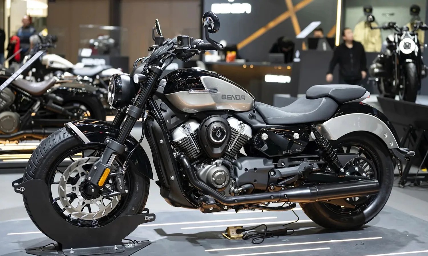 Black and silver Benda BD250-160 cruiser motorcycle on display stand indoors.
