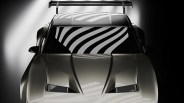 Front view of a sleek silver sports car with sharp angular hood vents and a large rear spoiler.