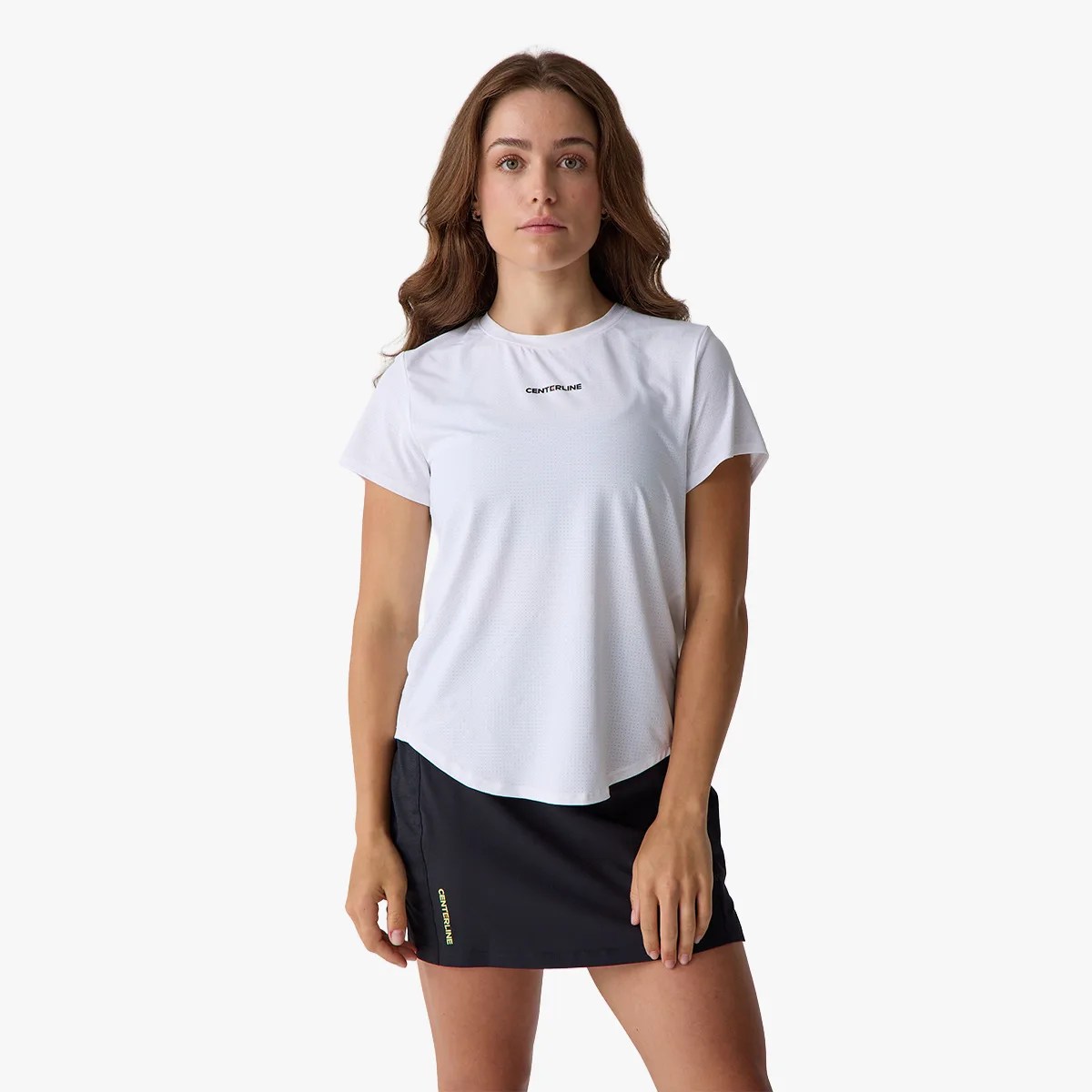 Woman wearing a white short-sleeve Centerline t-shirt and a black Centerline skirt.