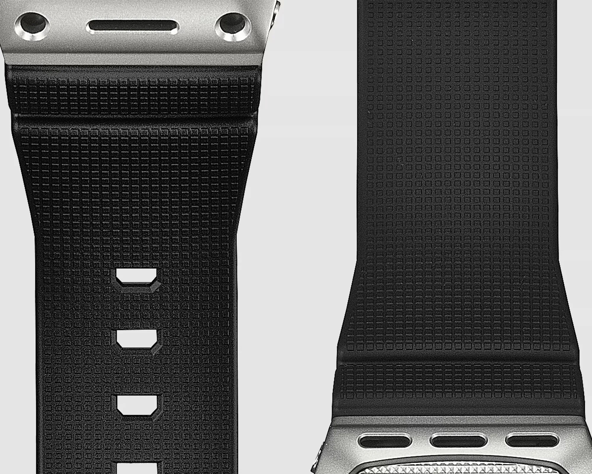 Black textured rubber watch straps with silver metal connectors on a light background.