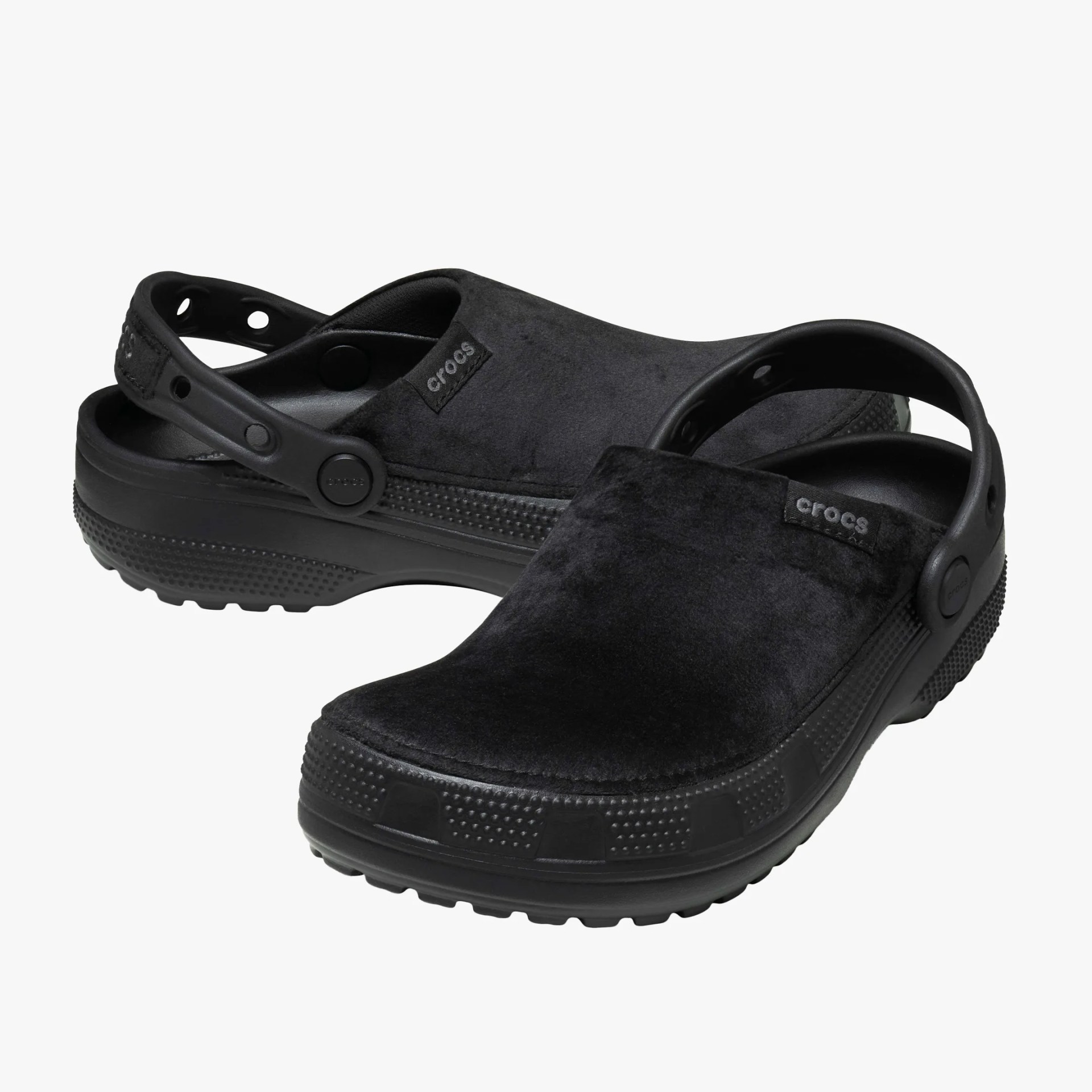 Pair of black Crocs clogs with a soft, velvety upper and adjustable heel straps.