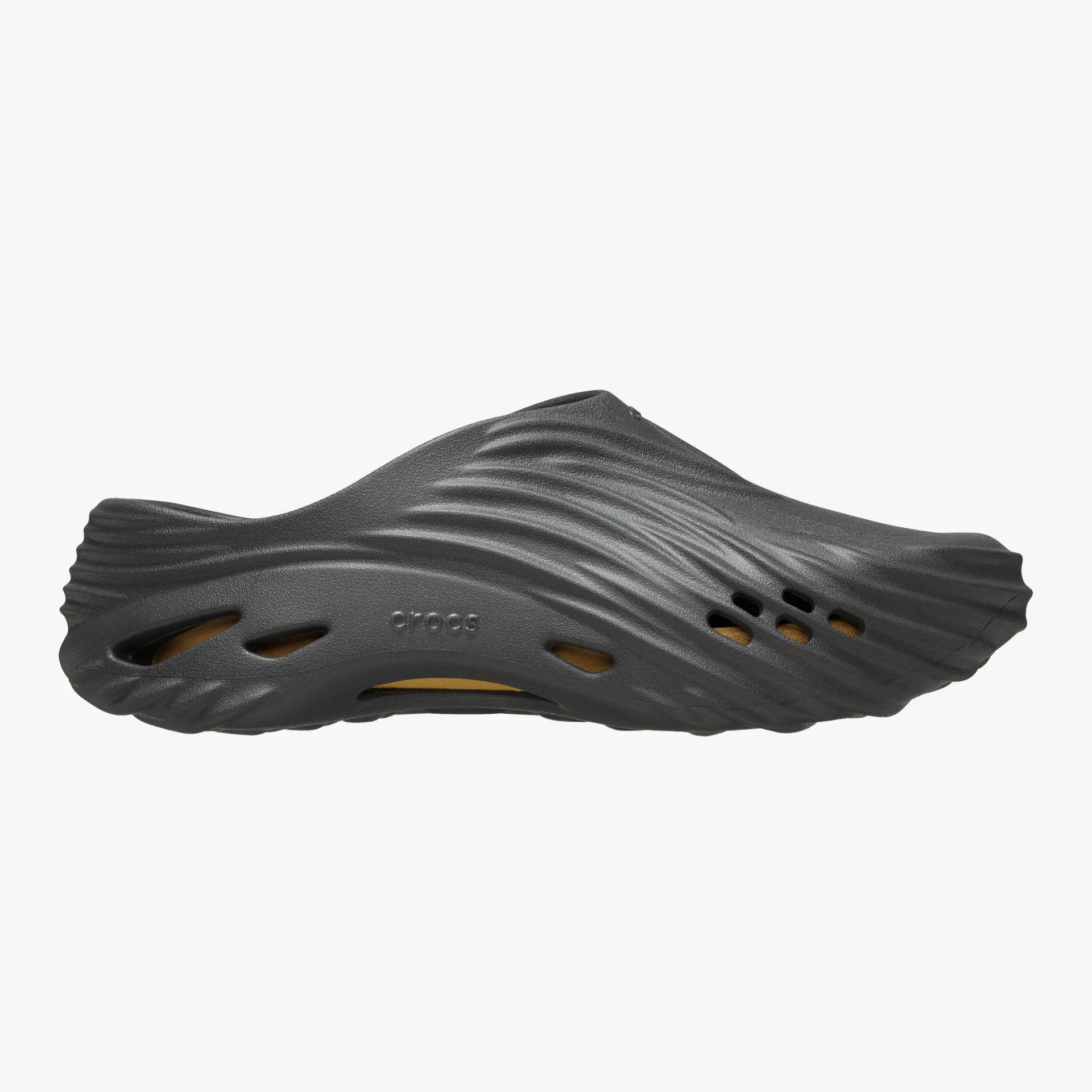 Black slip-on Crocs shoe with wave-like textured design and ventilation holes on the sides.