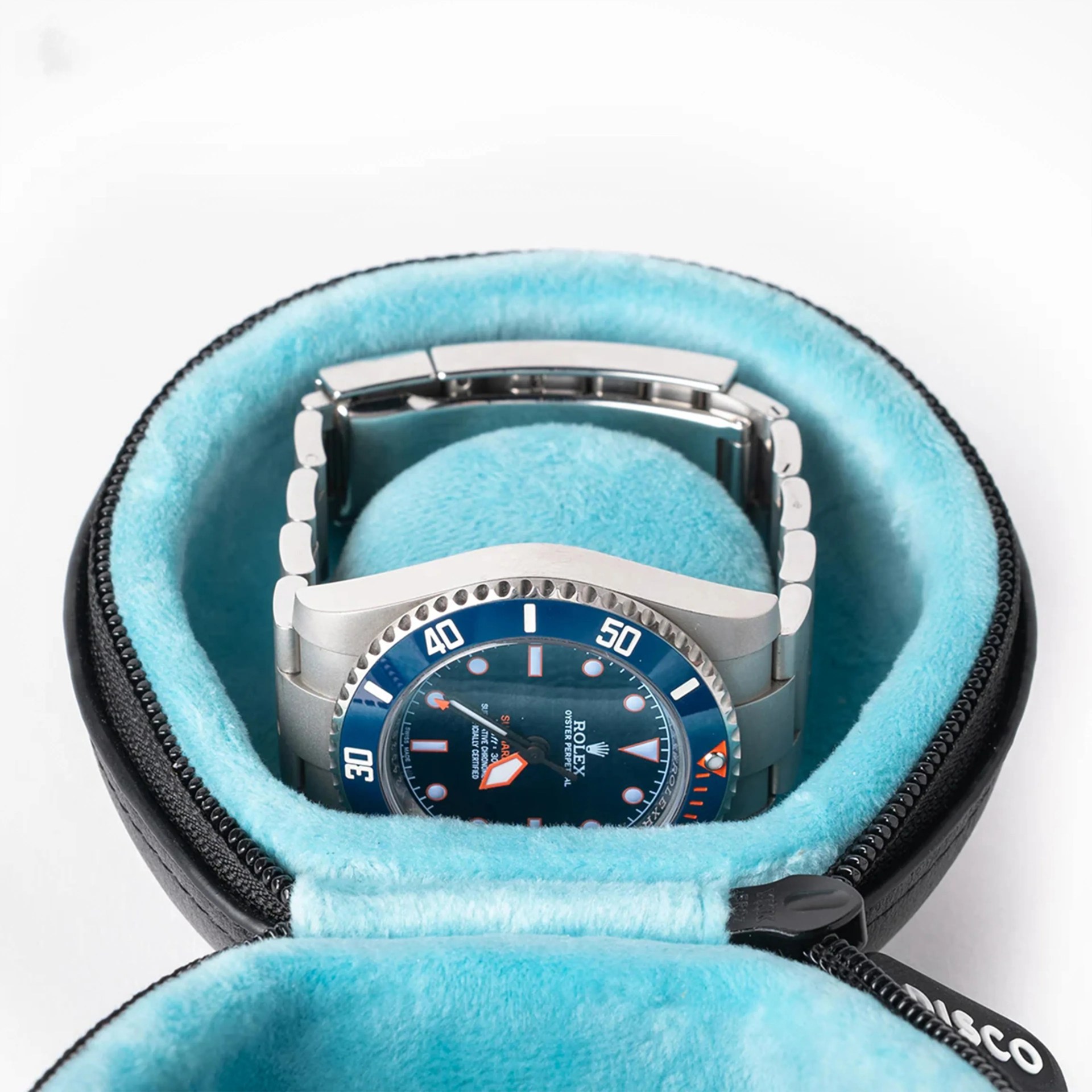 Silver Rolex Oyster Perpetual watch with blue dial and bezel inside a black and light blue zippered case.