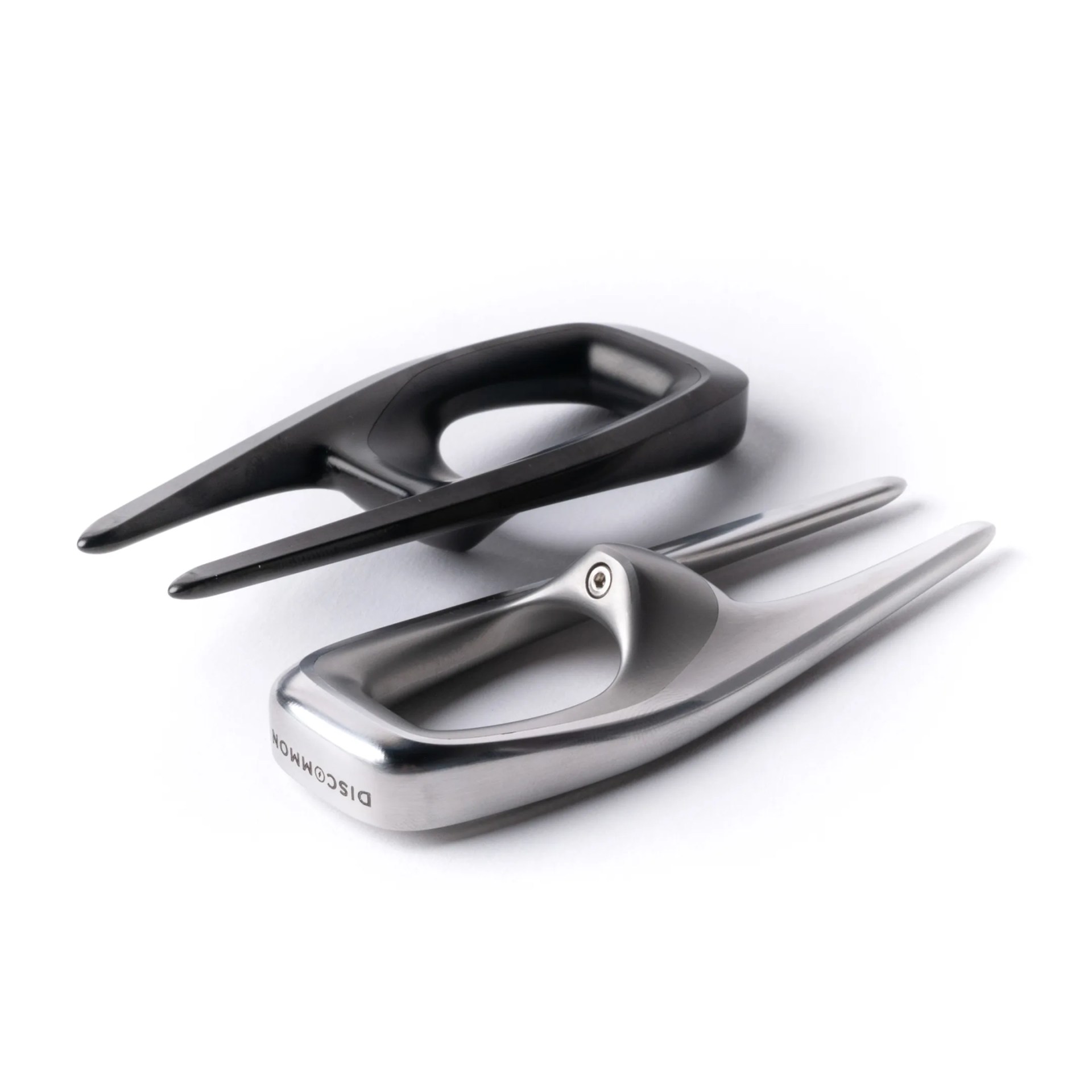 Two sleek, modern golf divot repair tools, one black and one silver, with ergonomic handles on a white background.
