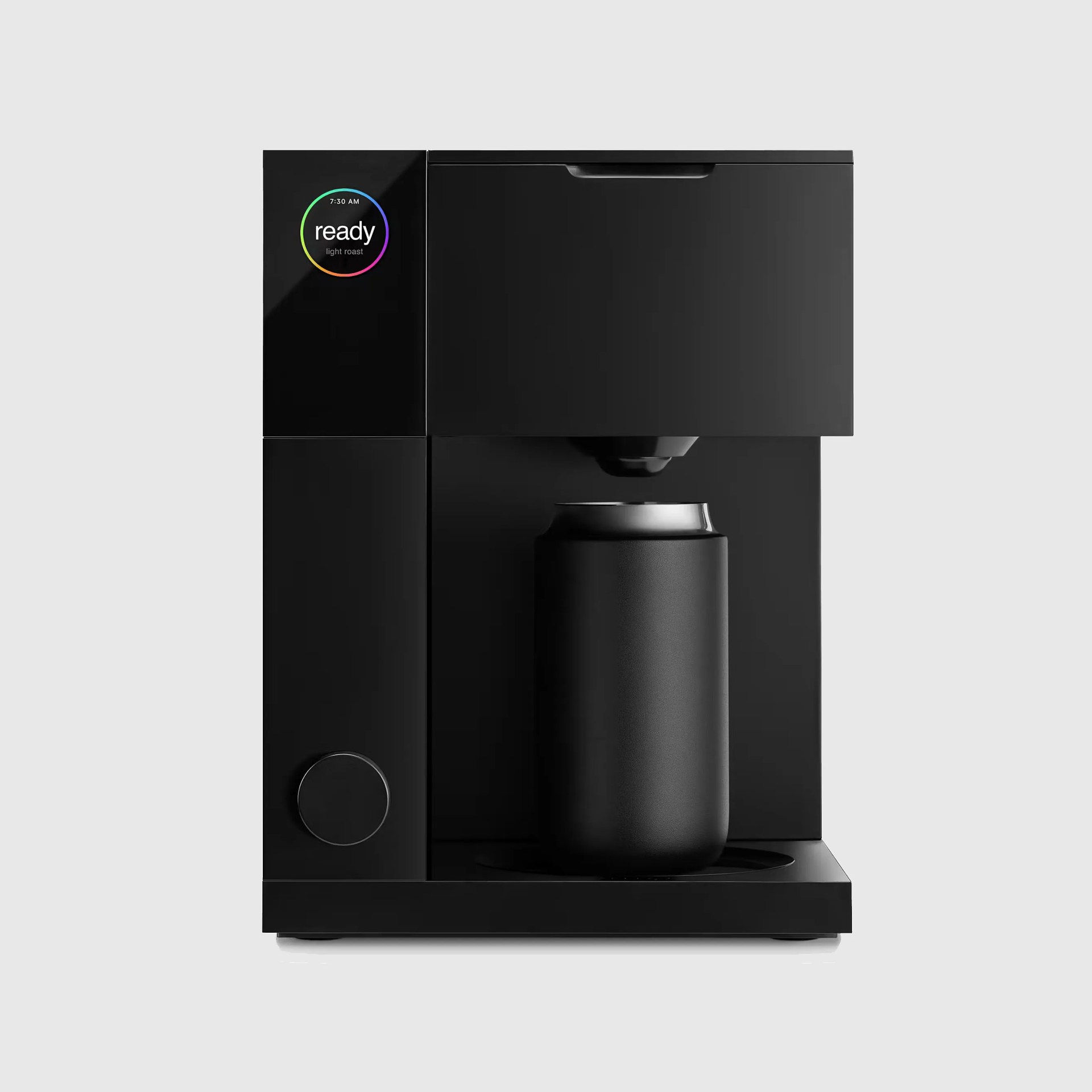 Matte black compact coffee maker with a digital display and a black can placed under the dispenser.