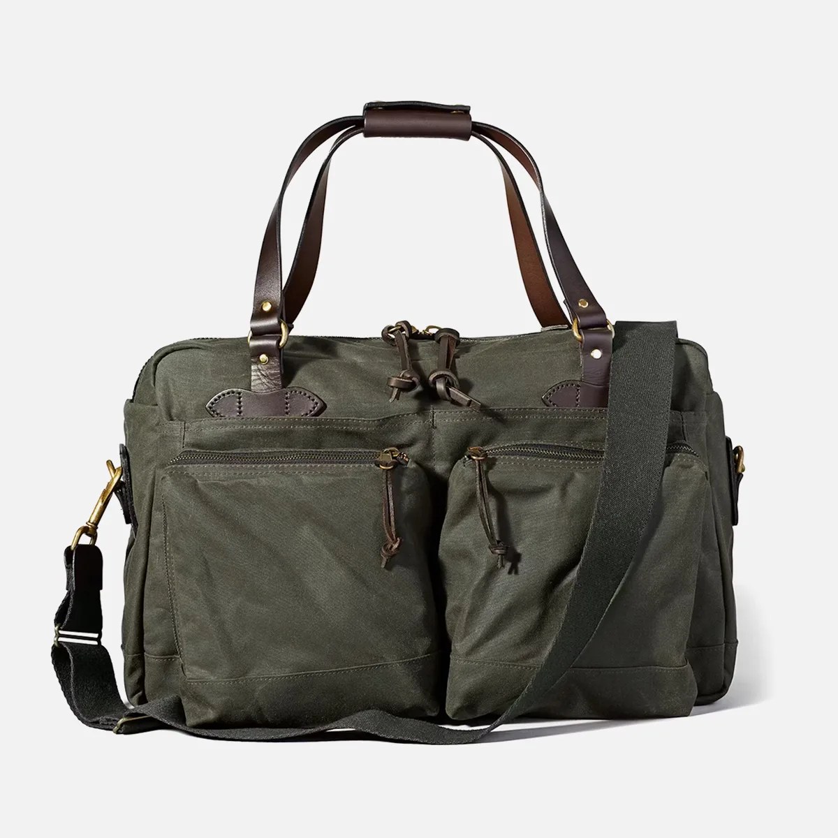 Olive green canvas duffel bag with dark brown leather handles and adjustable shoulder strap.