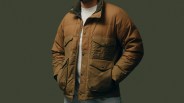 Brown and olive green insulated jacket with snap-button flap pockets worn over a white shirt.