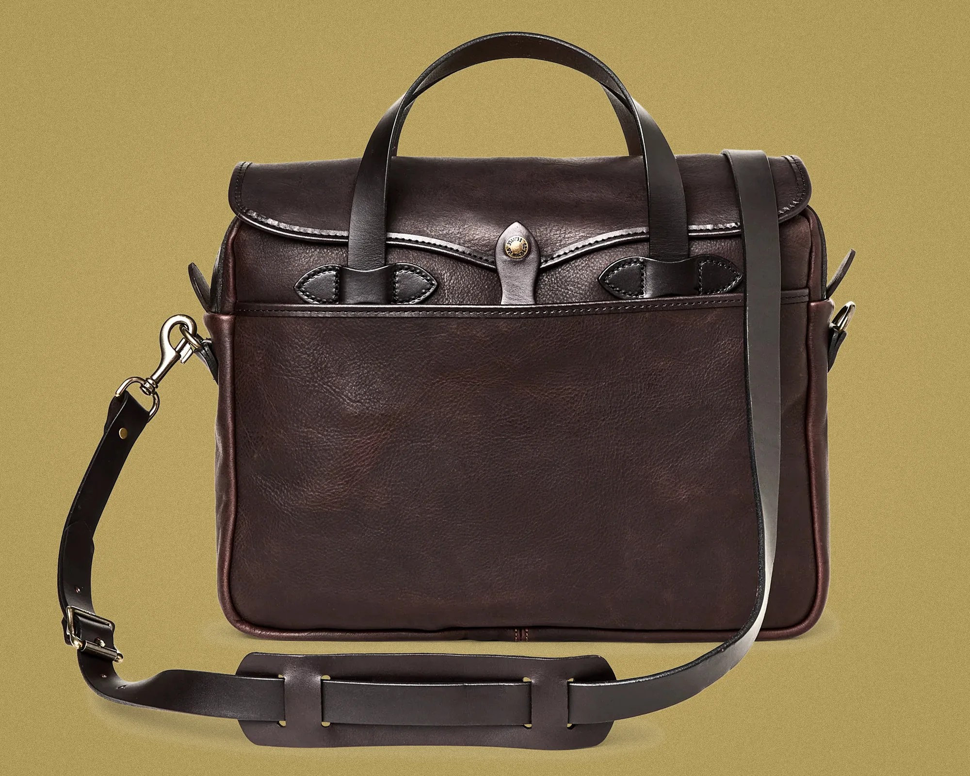 Dark brown leather briefcase with top handles and adjustable shoulder strap on a beige background.