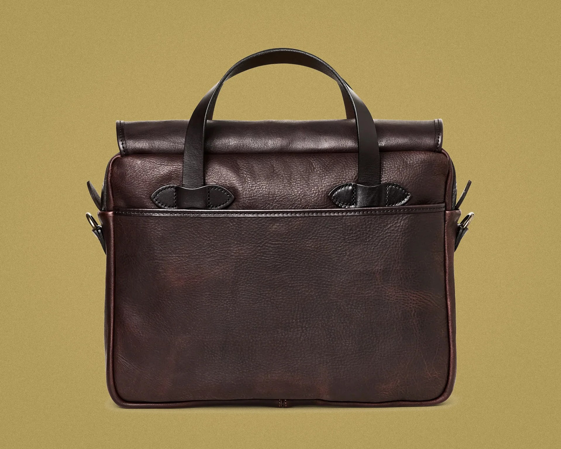Dark brown leather briefcase with black handles against a beige background.